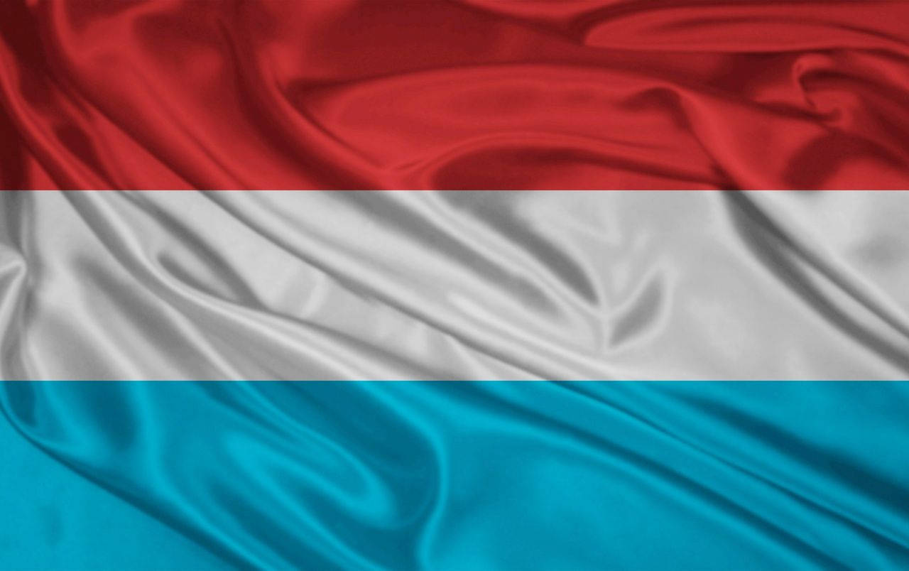 Luxembourg 桌布 壁紙 — 盧森堡國旗，紅、白、淺藍色橫條在柔軟布料褶皺中飄揚。