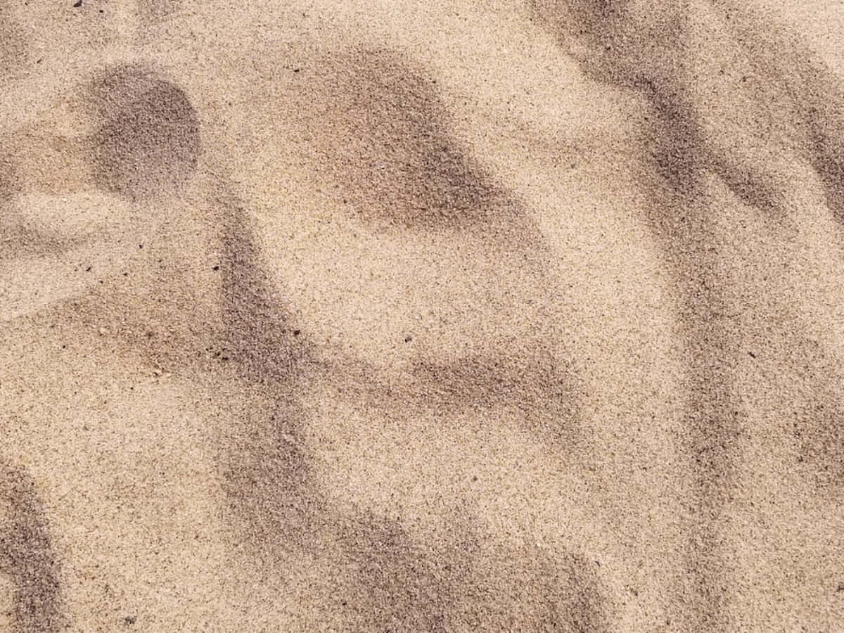 sand 桌布 壁紙 — 看不見物體投射的柔和陰影在紋理沙子上形成抽象圖案的近距離特寫。