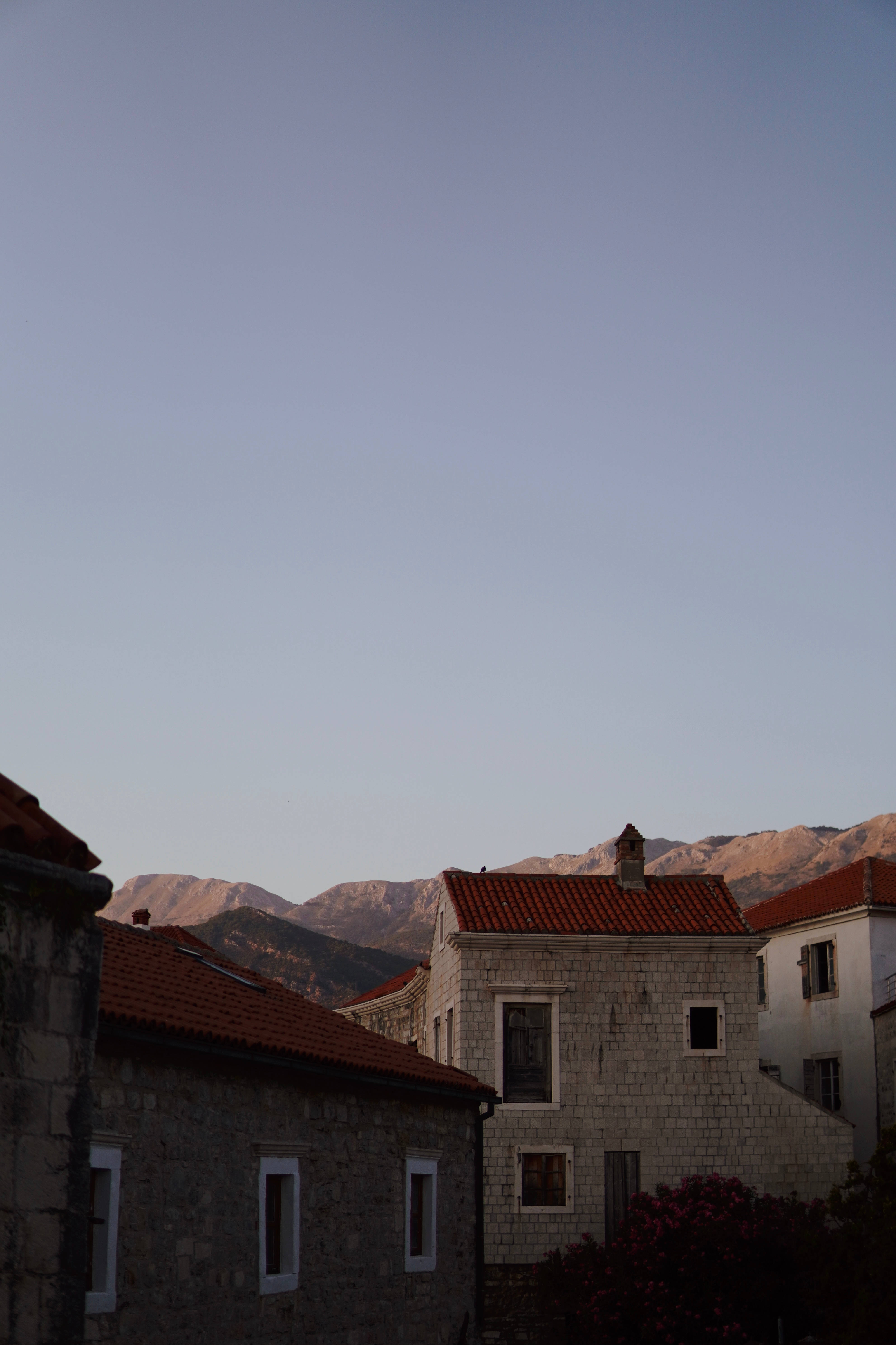 Montenegro 桌布 壁紙 — 石屋配紅瓦屋頂，在柔和暮色下襯托遠山。
