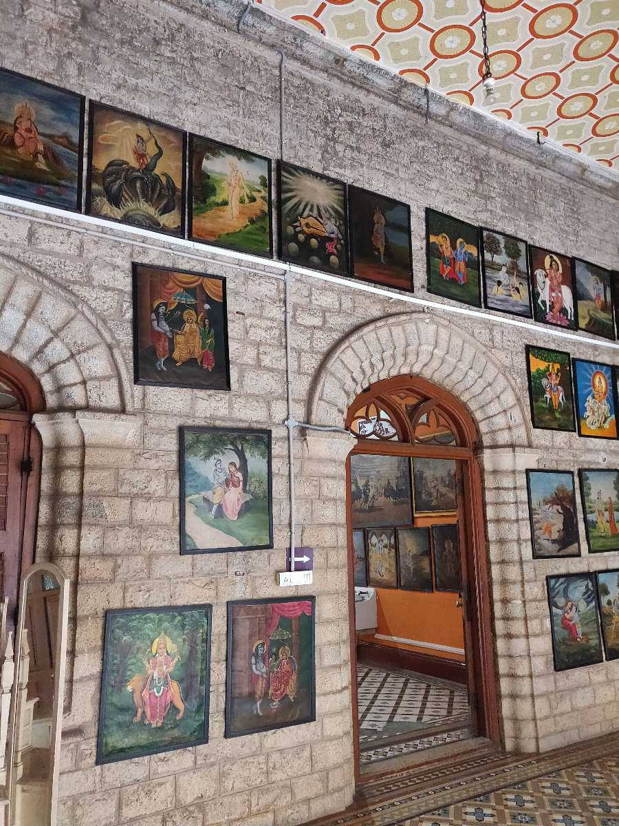 Bangalore 桌布 壁紙 — 石牆畫廊在圖案天花板和拱形門廊下展示色彩繽紛的裱框宗教畫作。