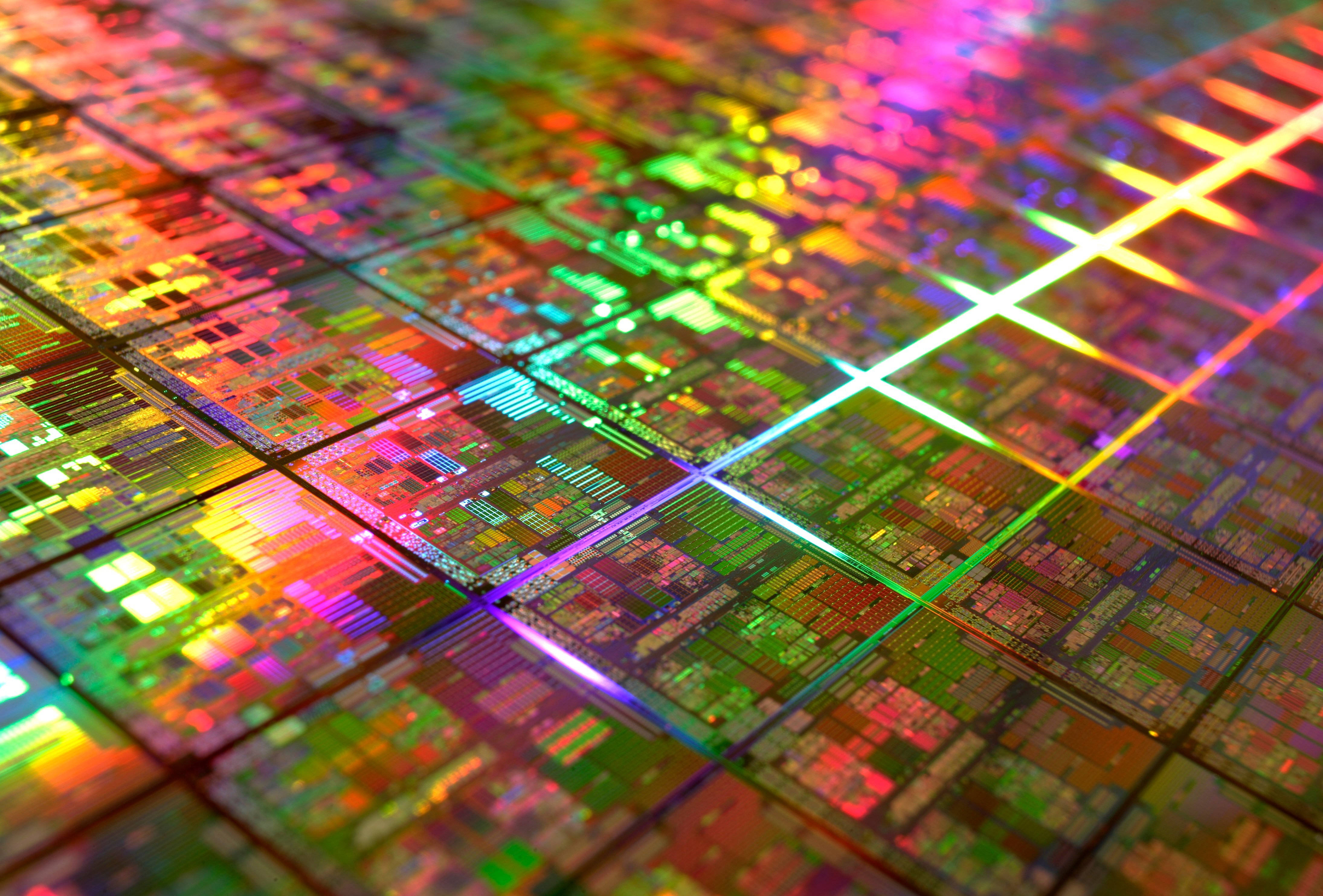 Processor 桌布 壁紙 — 矽晶圓的特寫，帶有在鮮豔光線下發光的彩色電路圖案。