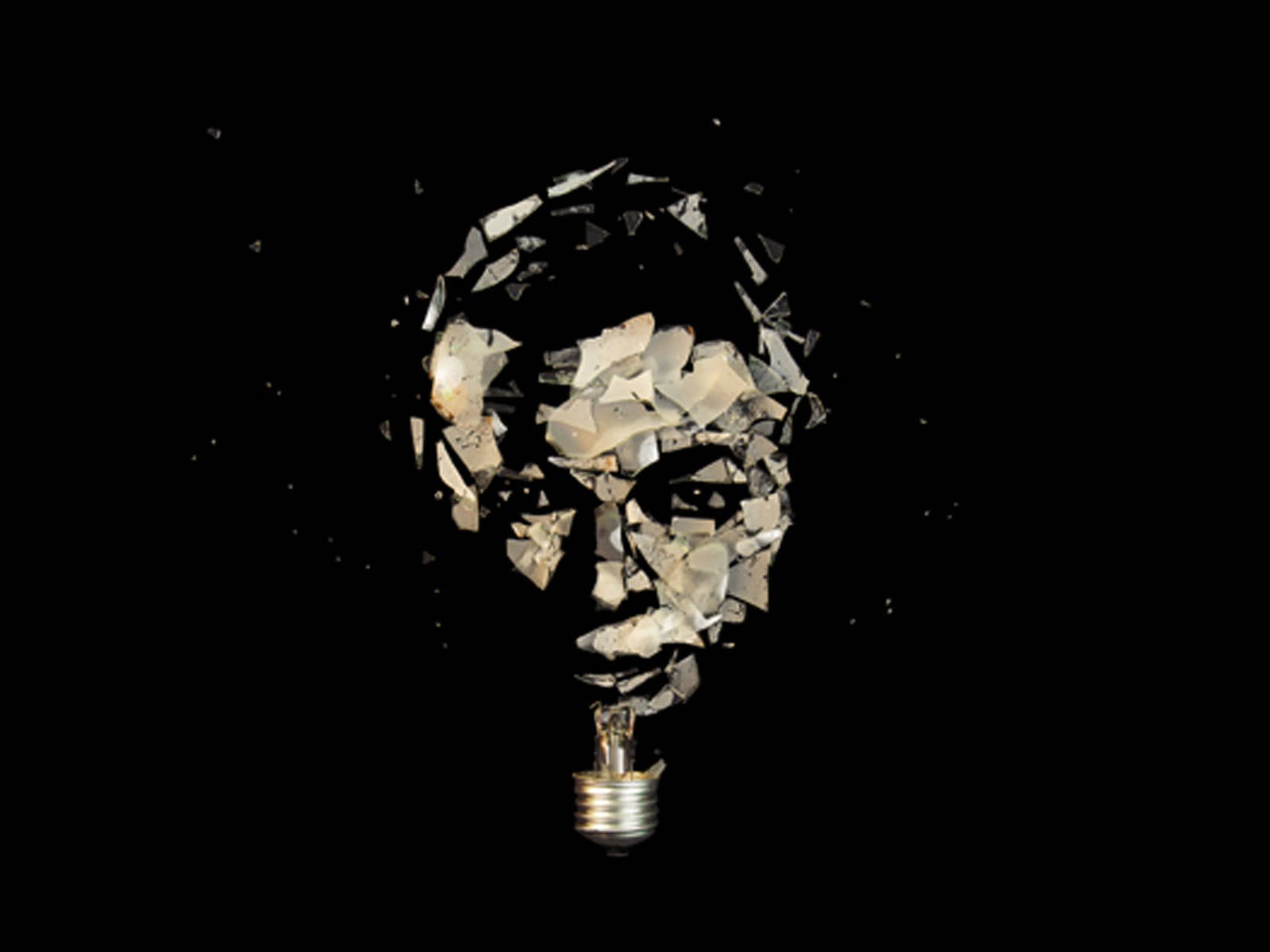 lightbulb 桌布 壁紙 — 破碎的燈泡在黑色背景上形成一個破碎的人臉。