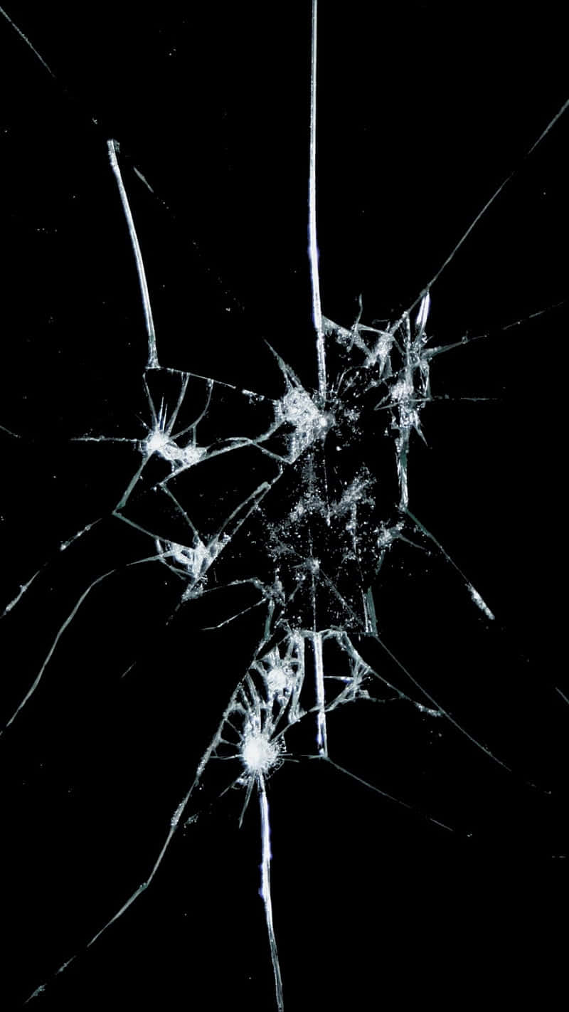 Broken 桌布 壁紙 — 破碎的玻璃表面，在純黑色背景上從撞擊點輻射出複雜的裂紋。