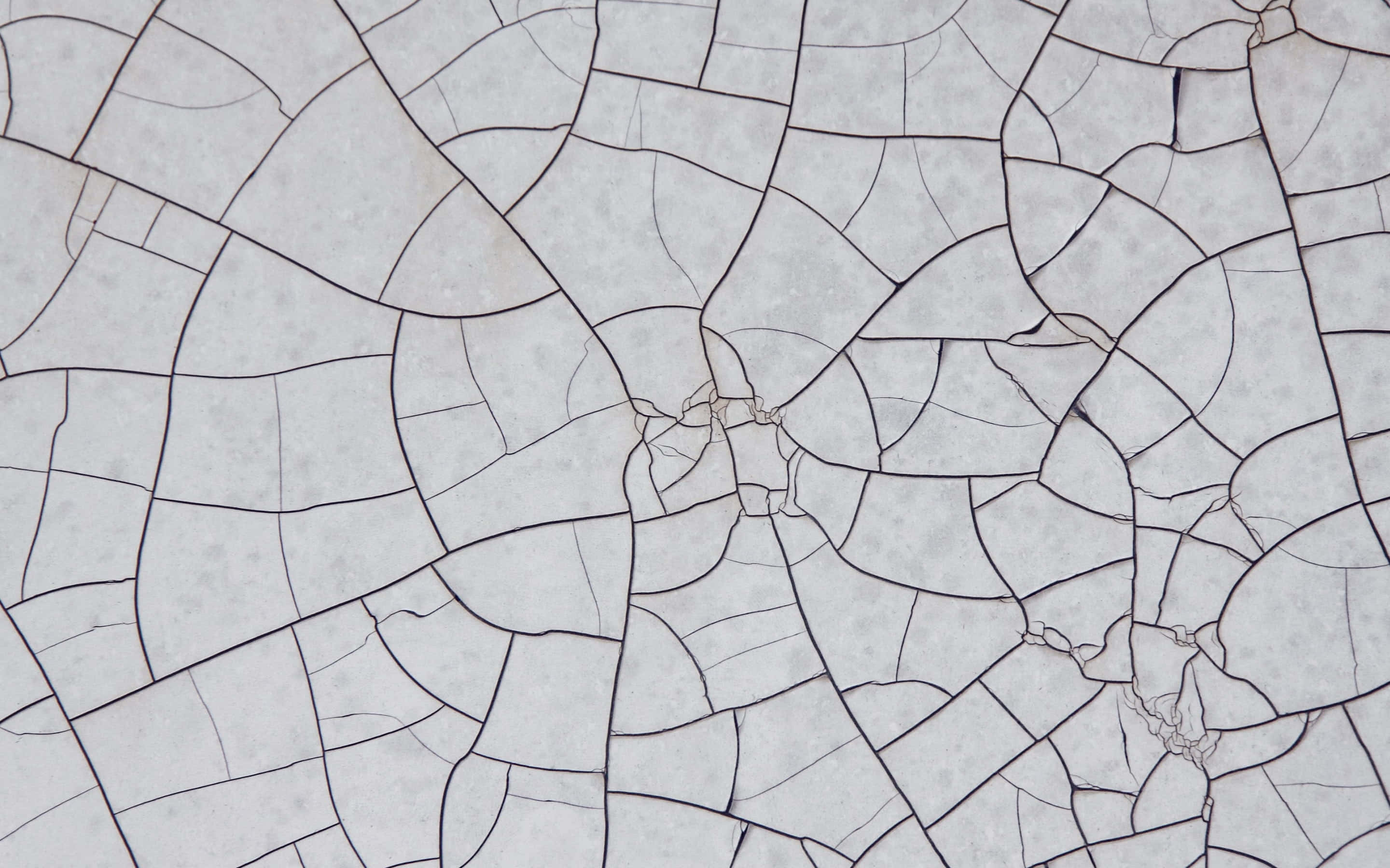 Cracks Texture 桌布 壁紙 — 破裂陶瓷磚表面的特寫，具有不規則幾何圖案和柔和灰色調。