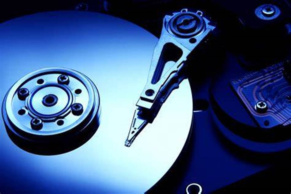 Hard Drive 桌布 壁紙 — 硬碟碟片及讀寫頭在冷藍燈光下的特寫。