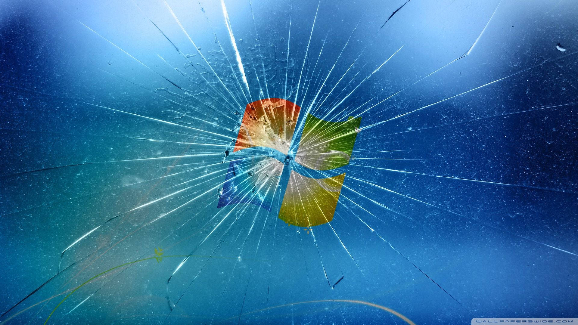 cracked 桌布 壁紙 — 碎裂玻璃效果覆蓋在Windows標誌上，背景為藍色漸層並帶有雨滴。