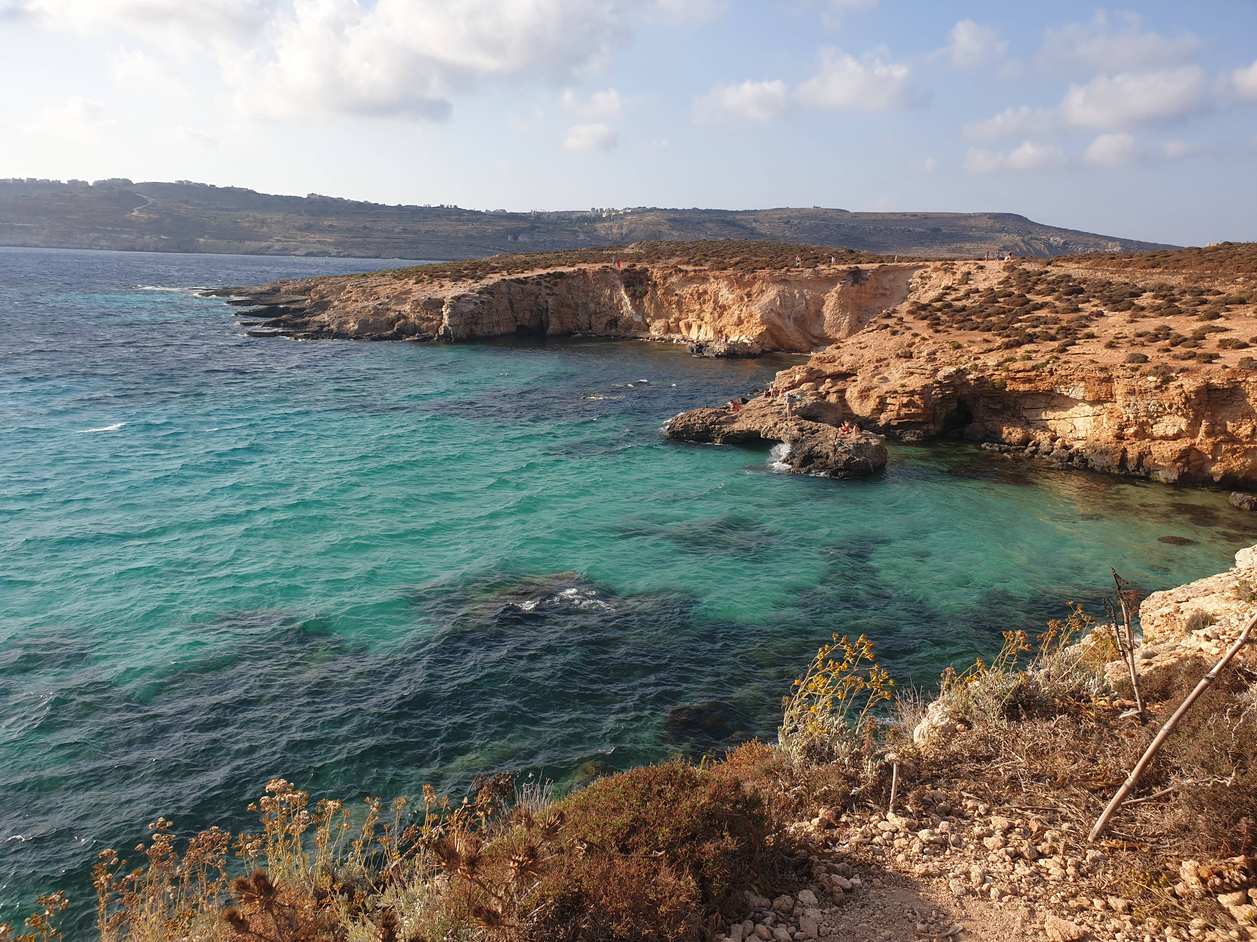Malta 桌布 壁紙 — 碧綠色的海水拍打著崎嶇的金色懸崖，天空湛藍，白雲點點。