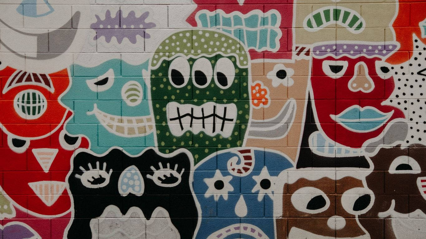 塗鴉 桌布 壁紙 — 磚牆上色彩鮮豔的塗鴉壁畫，描繪風格化的卡通面孔，色彩大膽，圖案俏皮。