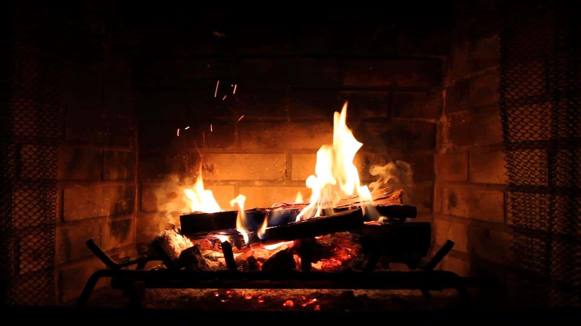 Cozy 桌布 壁紙 — 磚砌壁爐中熊熊燃燒的火焰，將溫暖的橙色光芒投射到周圍的石材和金屬網上。