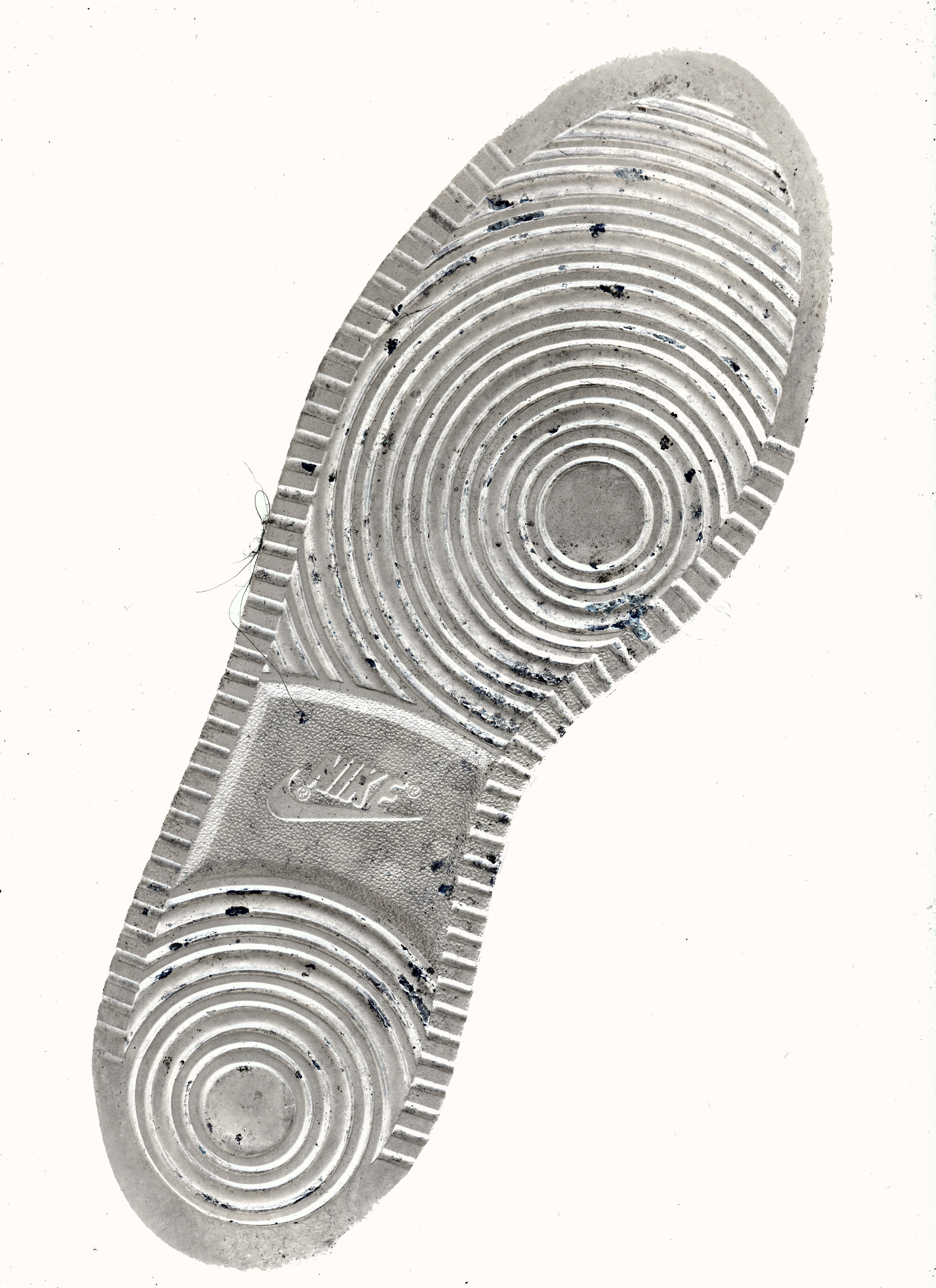 Shoe 桌布 壁紙 — 磨損的Nike鞋底特寫，帶有同心圓形胎面花紋和污漬，背景為純色。