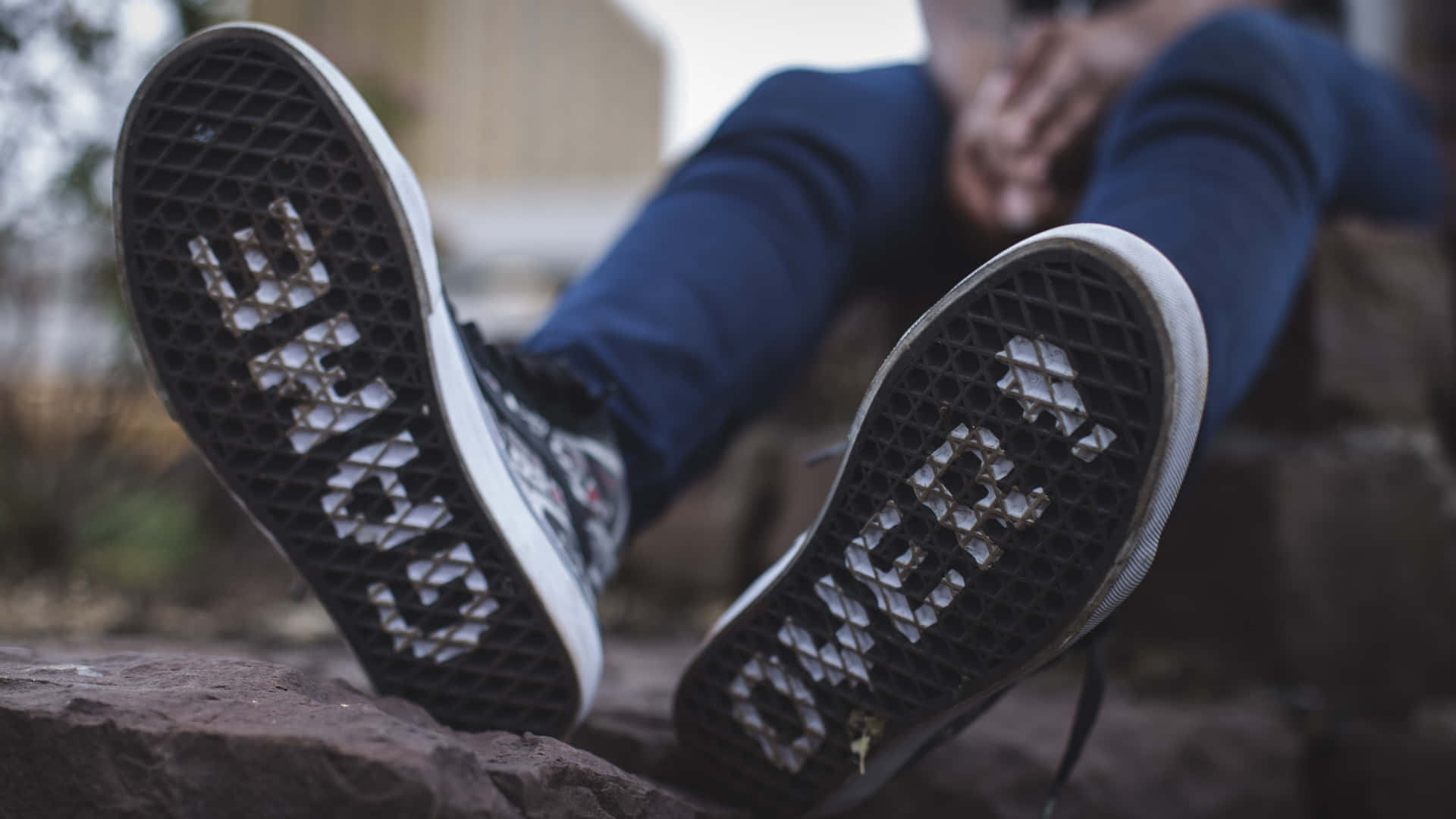 鞋子 桌布 壁紙 — 磨損的Vans運動鞋特寫，鞋底有明顯的「VANS」標誌，放在粗糙的石頭上。
