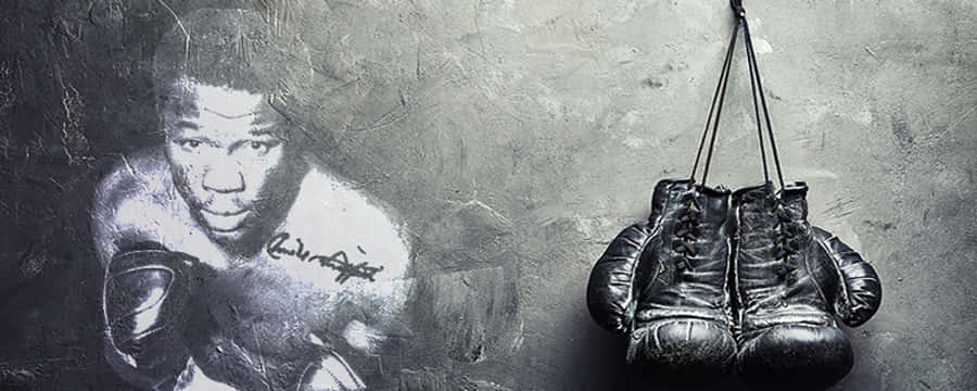 Boxing 桌布 壁紙 — 磨損的拳擊手套掛在紋理牆上一個粗糙的拳擊手壁畫旁邊。