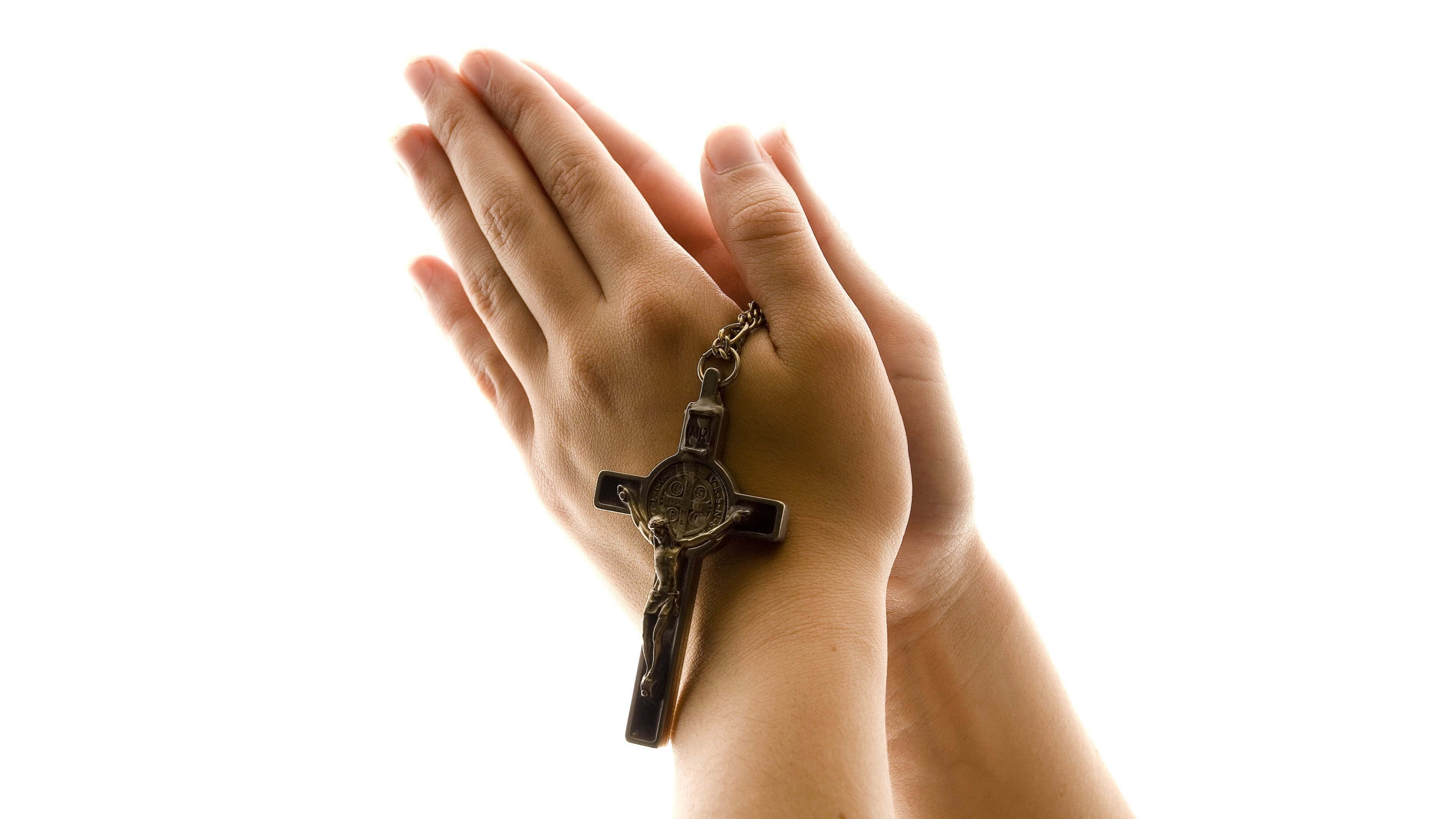 Praying 桌布 壁紙 — 祈禱中緊握的雙手，手持十字架，背景為純白色。