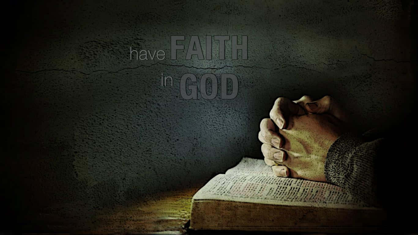 Faith 桌布 壁紙 — 祈禱的手放在打開的聖經上，在昏暗的光線下，裂縫牆上有「have FAITH in GOD」的文字。