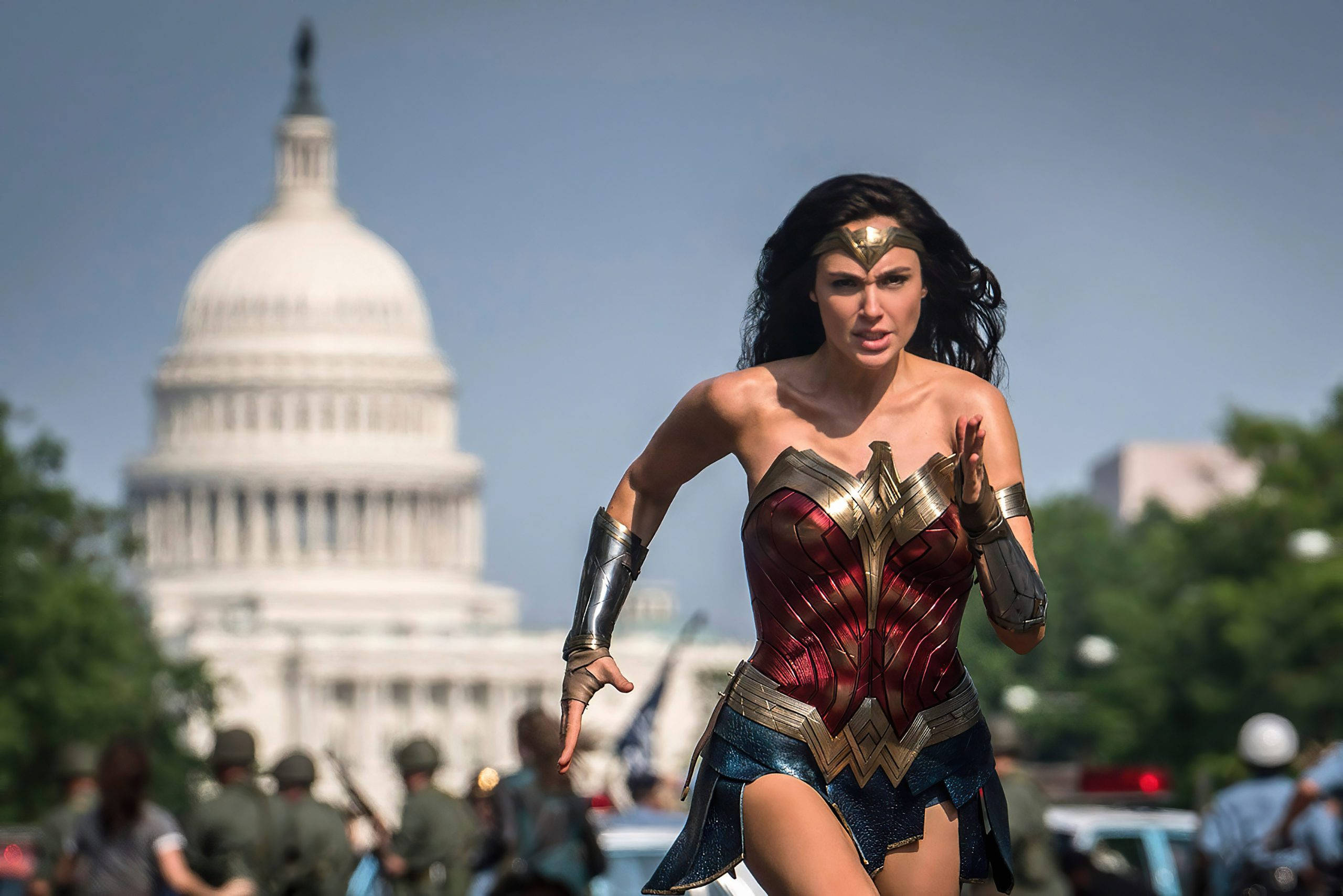 Wonder Woman 1984 桌布 壁紙 — 神力女超人在明亮的日光下，動態地奔跑在美國國會大廈前。