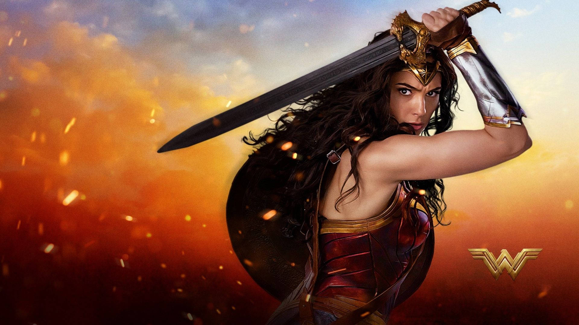 Wonder Woman 桌布 壁紙 — 神力女超人在火花四濺的熾熱日落背景下揮舞著她的劍和盾牌。