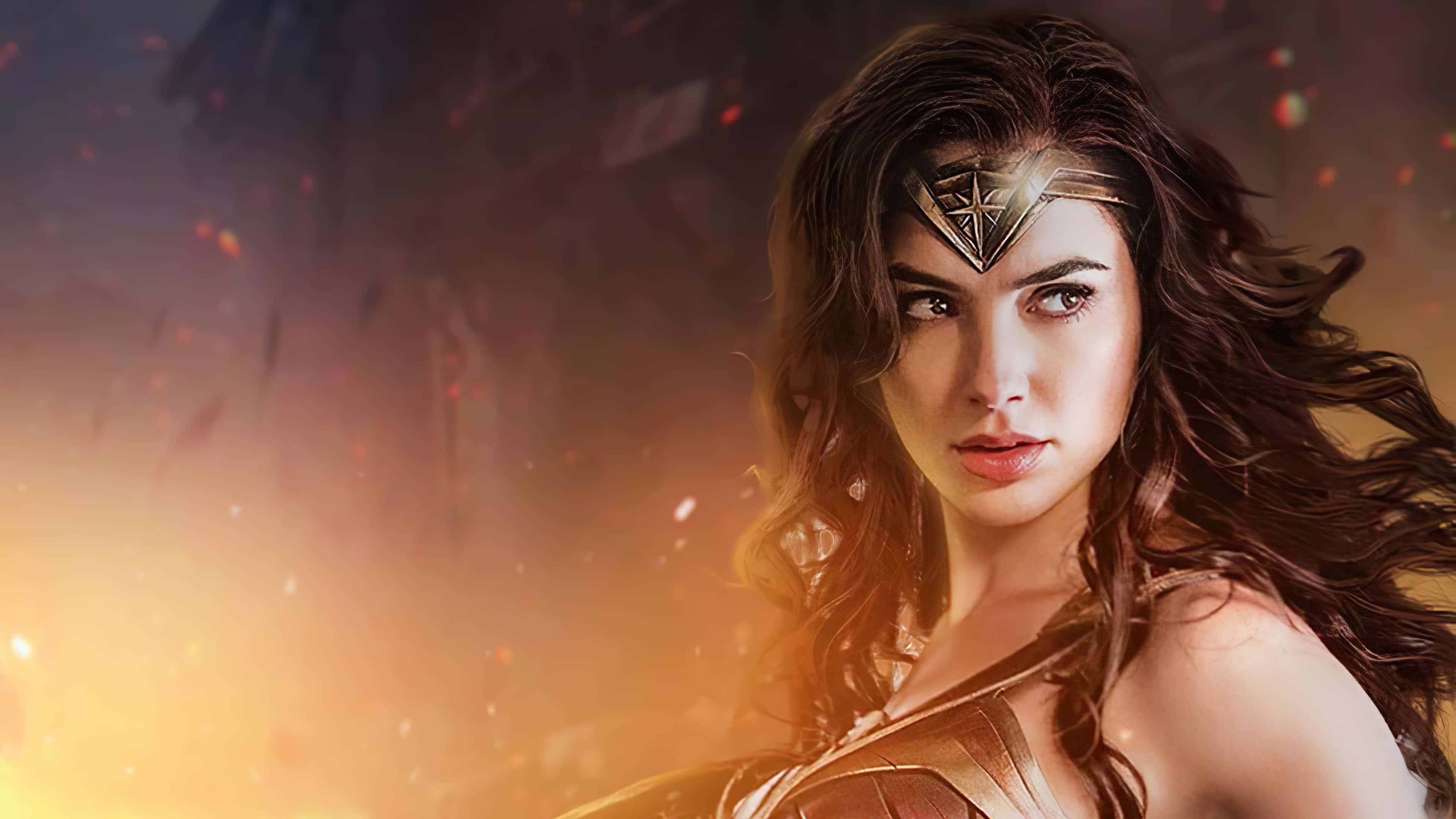 Wonder Woman 桌布 壁紙 — 神力女超人穿著金色盔甲，在熾熱的戰場背景下英勇站立，發光的餘燼在她周圍旋轉。
