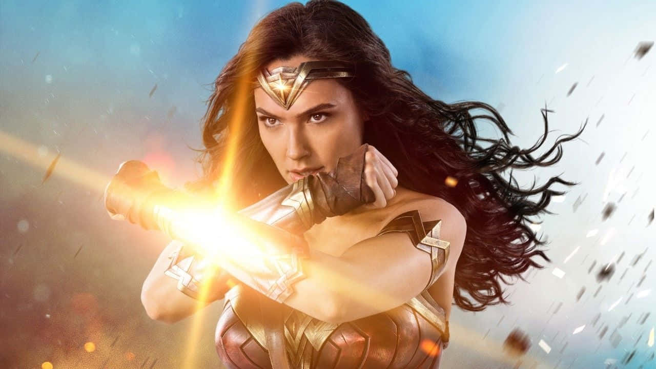 Wonder Woman 桌布 壁紙 — 神力女超人穿著金色盔甲，在飛揚的碎片和耀眼的光芒中，用發光的真言套索引導力量。