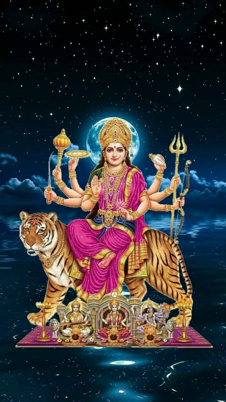 Durga 桌布 壁紙 — 神聖的女神杜爾迦身著閃亮的粉紅色和金色服飾，在滿月星空下騎著雄偉的老虎。