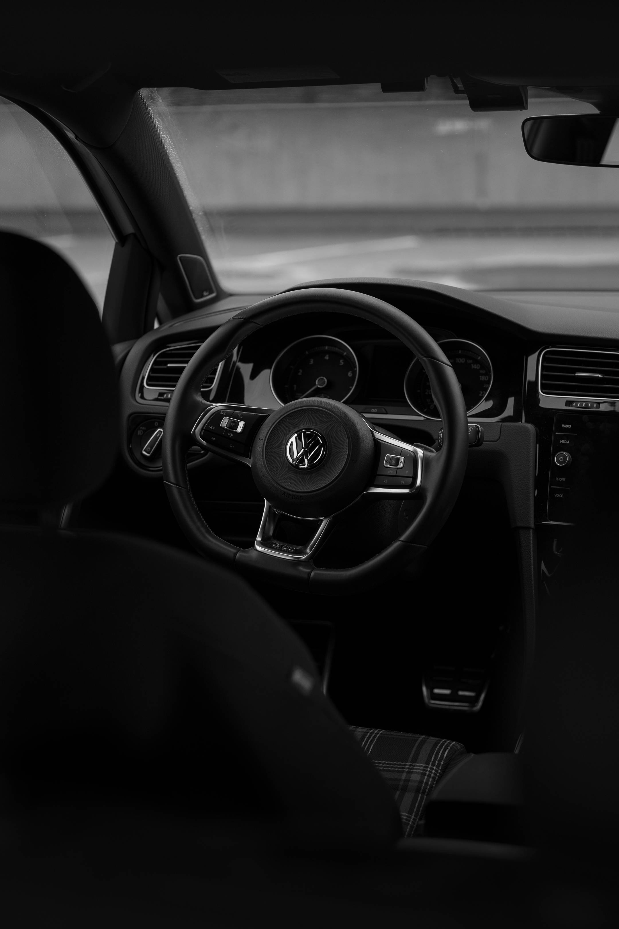 Gti 桌布 壁紙 — 福斯汽車駕駛艙的單色內部照片，聚焦於方向盤和儀表板。