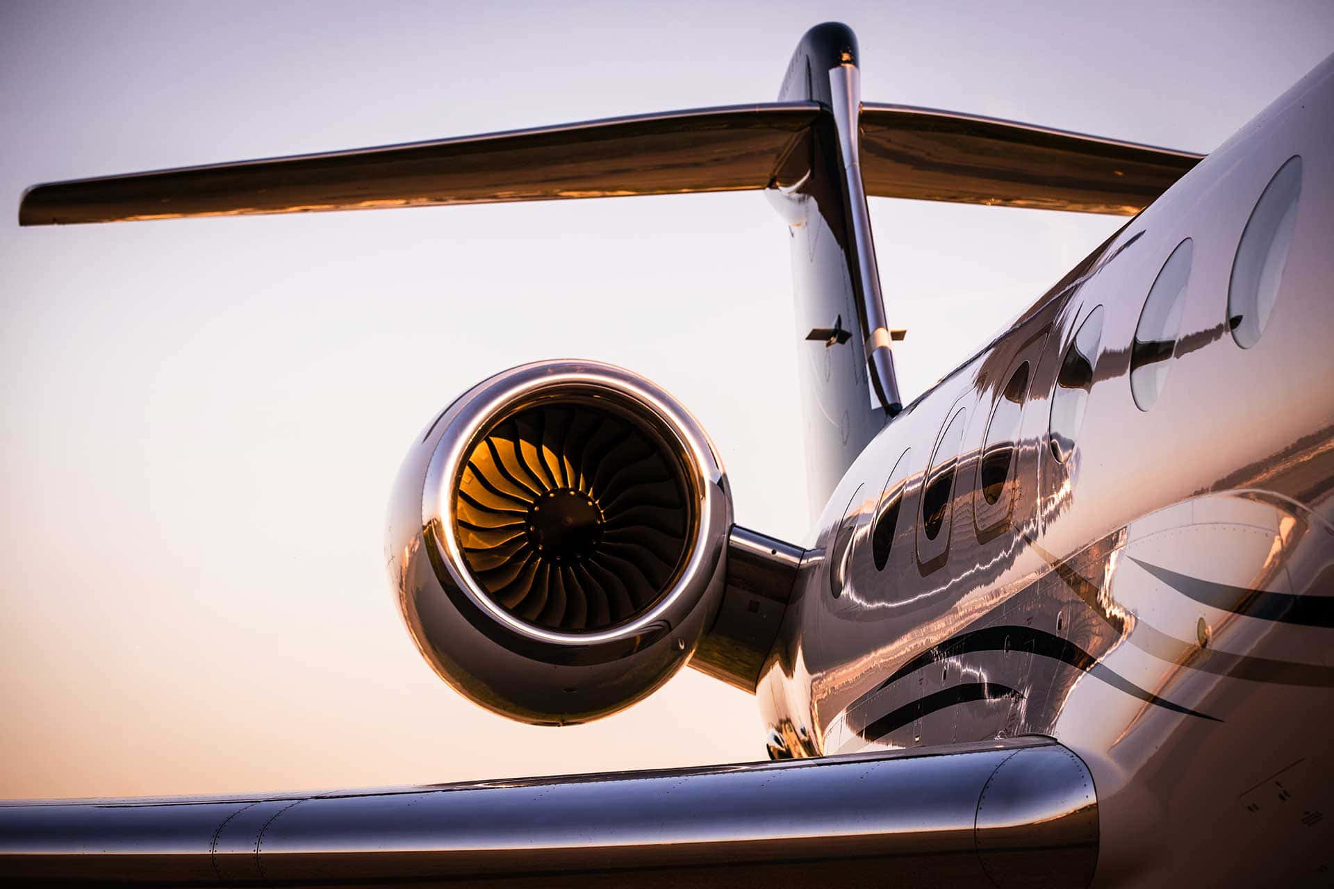 Aviation 桌布 壁紙 — 私人飛機引擎和機身的特寫，在溫暖的日落光線下閃閃發光。