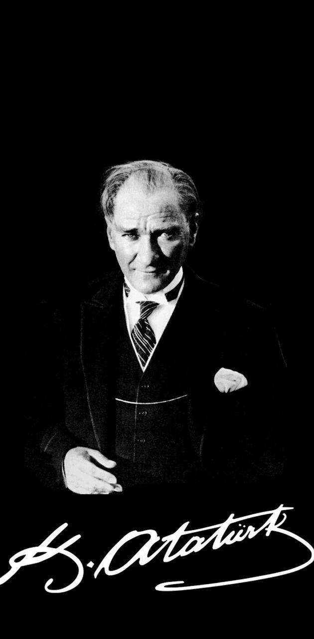 Ataturk 桌布 壁紙 — 穆斯塔法·凱末爾·阿塔圖爾克的醒目黑白肖像，身著正裝，背景深色，下方有他的簽名。