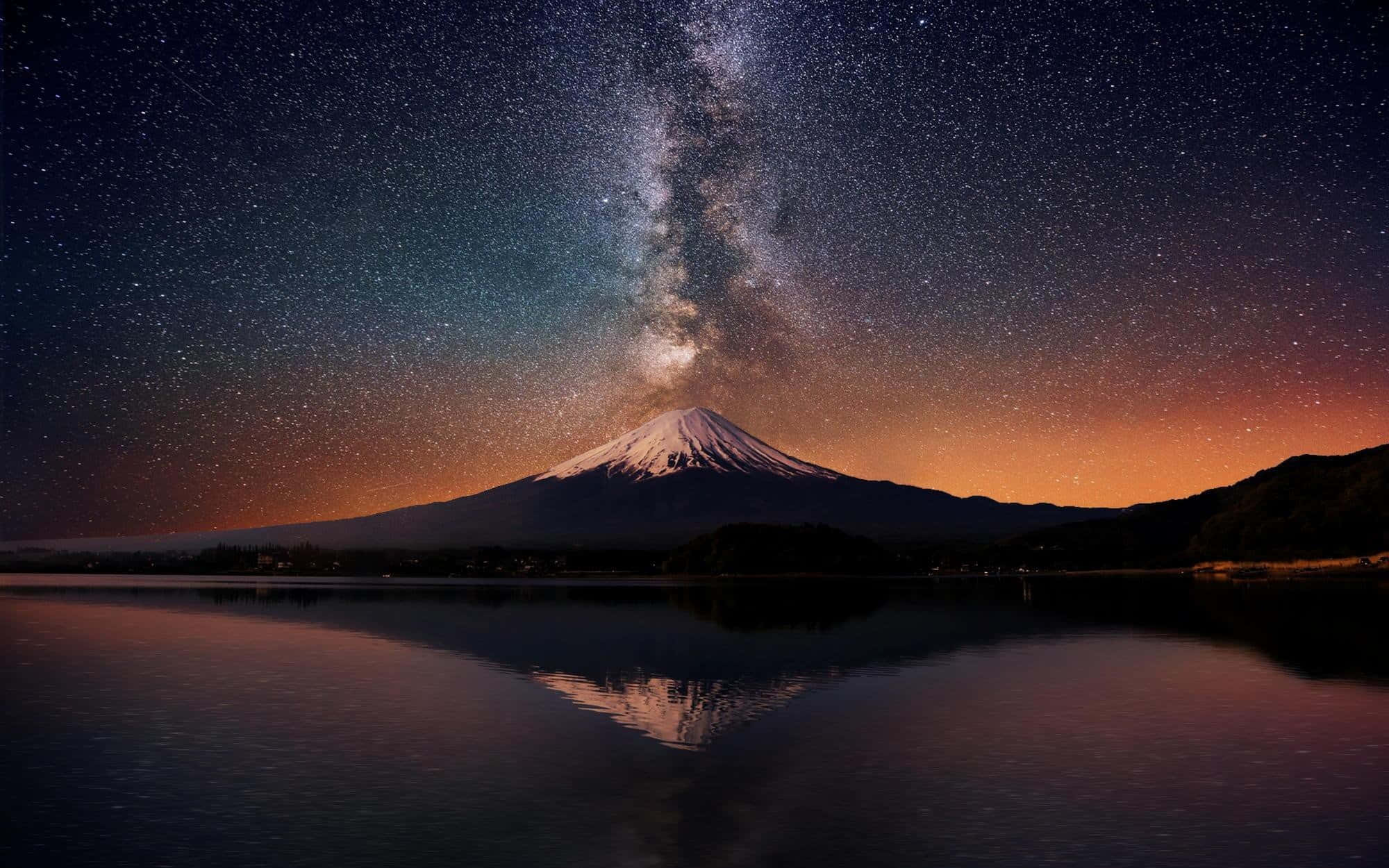 日本 桌布 壁紙 — 積雪的富士山在星空下倒映，銀河在平靜的湖面上拱起。