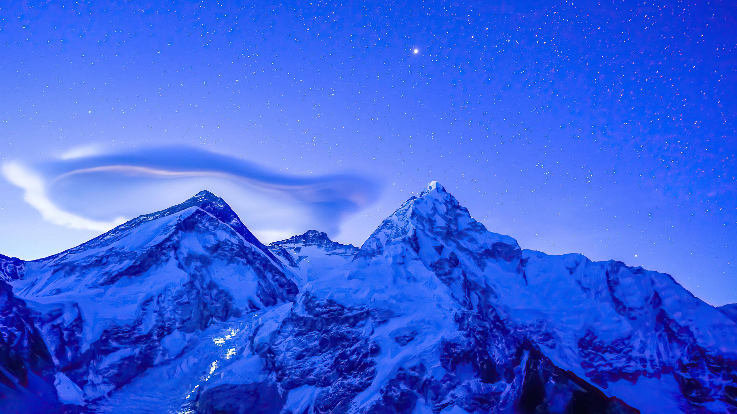 2560x1440 nature 桌布 壁紙 — 積雪的山峰刺穿星光璀璨的暮色天空，上方飄浮著發光的透鏡狀雲。