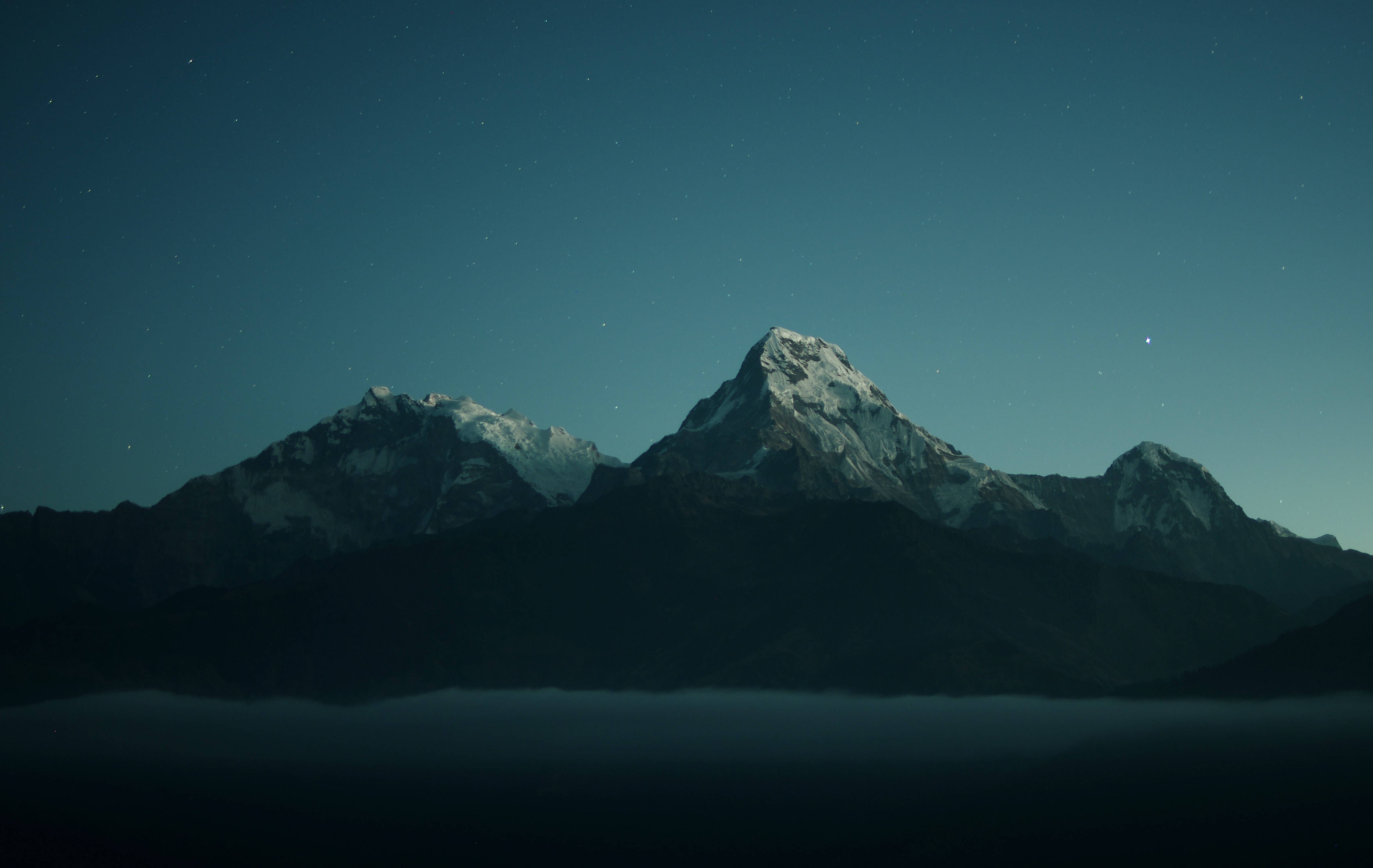 風景 桌布 壁紙 — 積雪的山峰刺穿繁星點點的夜空，下方是雲霧之海。