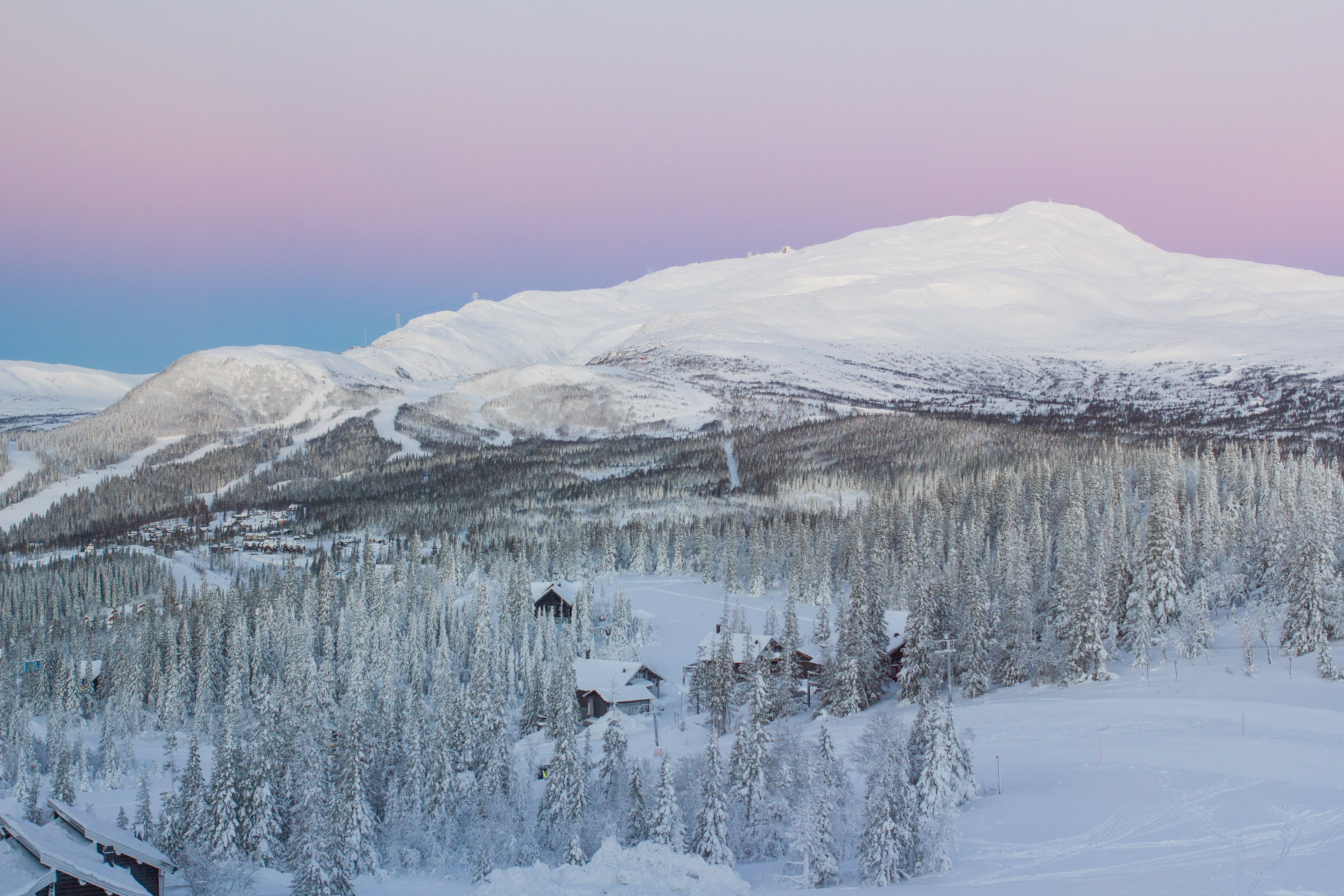 Sweden 桌布 壁紙 — 積雪的山峰和森林，在粉紅和藍色的暮色天空下，散落著小屋。