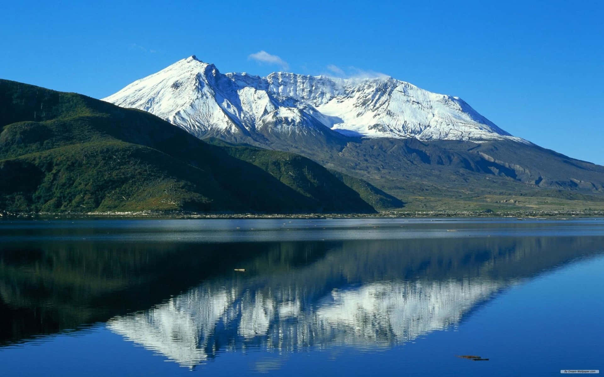 積雪的山峰完美地倒映在寧靜的藍色湖面上，天空明亮。 — 美麗風景動圖 壁紙