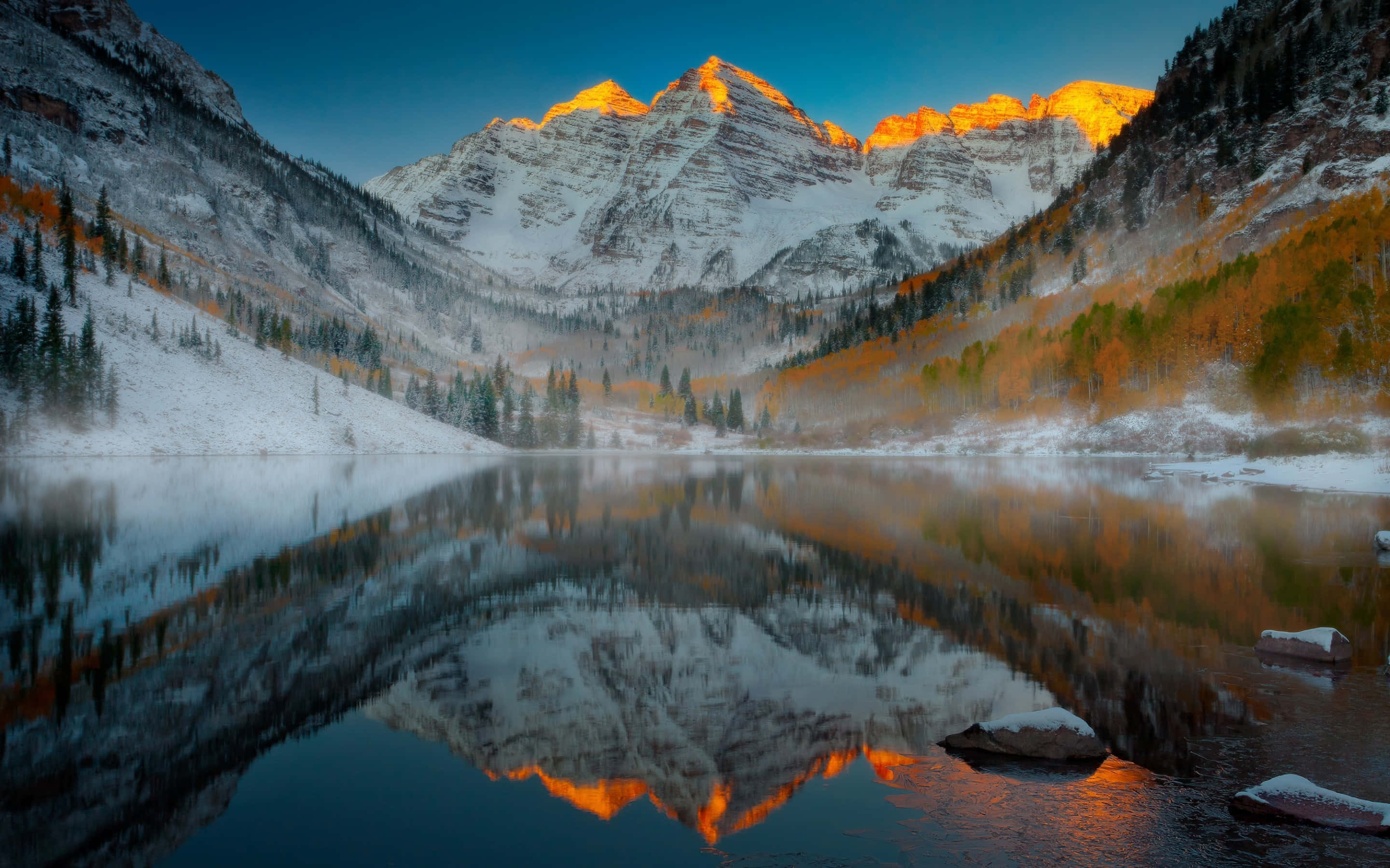 Aspen Colorado 桌布 壁紙 — 積雪的山峰在日出時閃耀金光，完美倒映在被秋樹環繞的霧氣湖中。