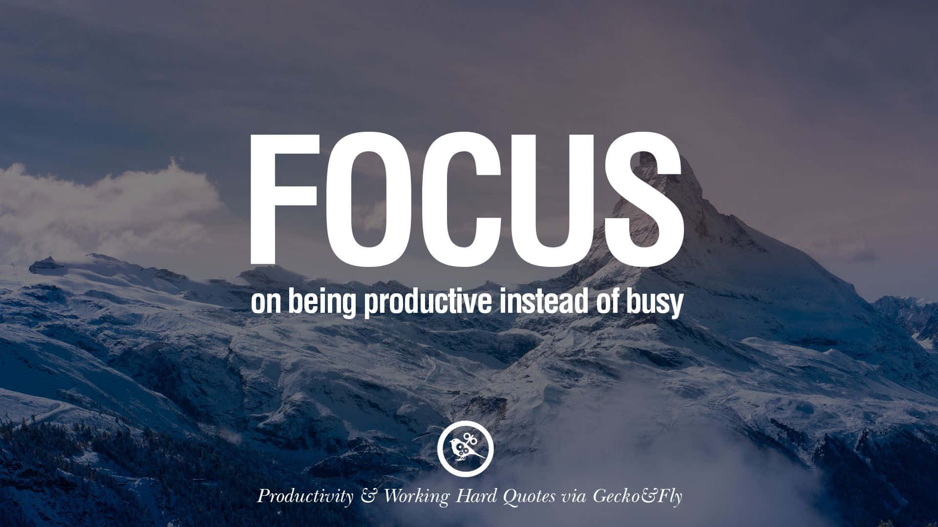Motivational Quotes 桌布 壁紙 — 積雪的山峰在陰沉天空下聳立，粗體白色文字敦促專注於生產力。