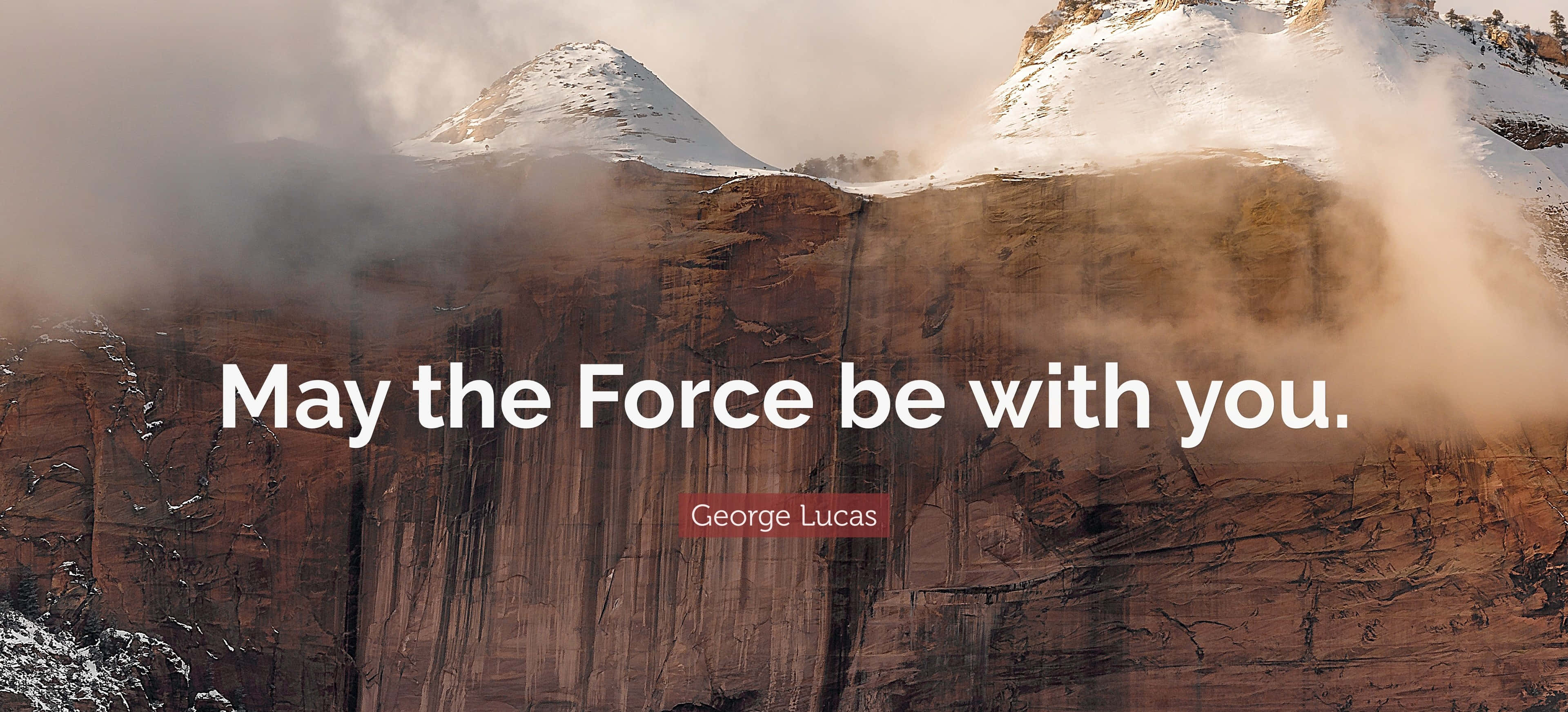 May The Force Be With You 桌布 壁紙 — 積雪的山峰在霧氣籠罩的懸崖後升起，上面覆蓋著喬治·盧卡斯的引言「May the Force be with you」。