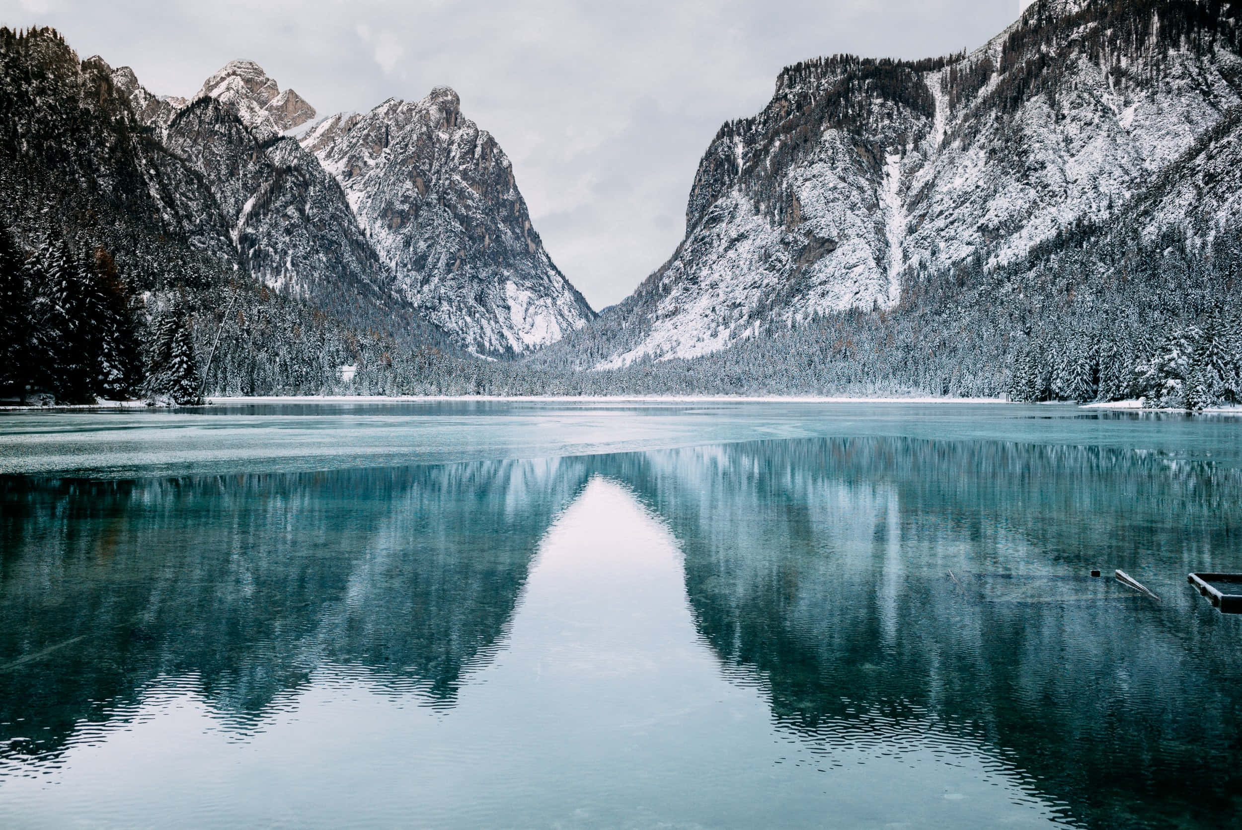 山景 桌布 壁紙 — 積雪的山峰完美地倒映在陰天下一片平靜的碧綠湖水中。