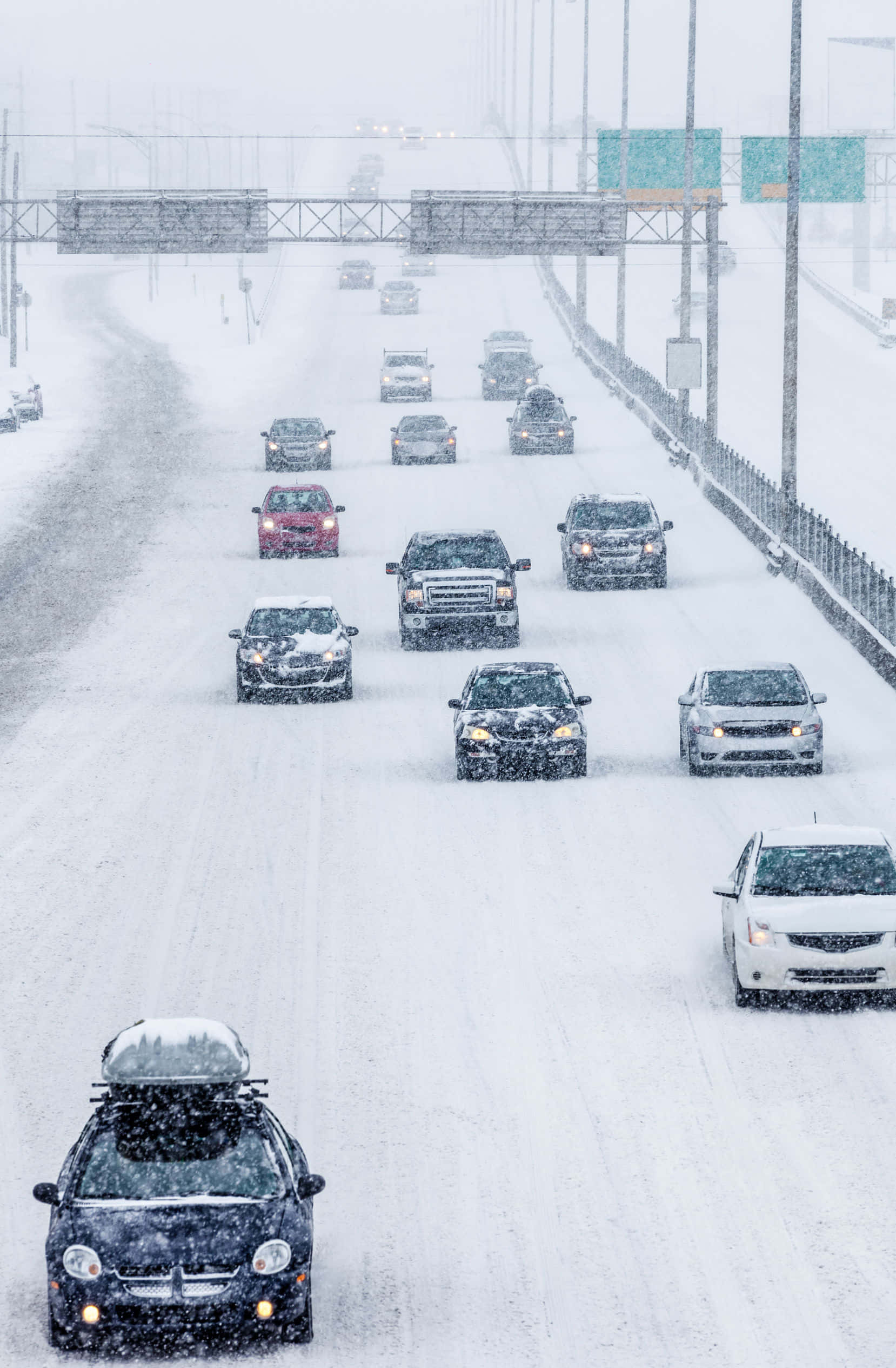 Winter Driving 桌布 壁紙 — 積雪的高速公路上，汽車在陰天大雪中謹慎行駛。