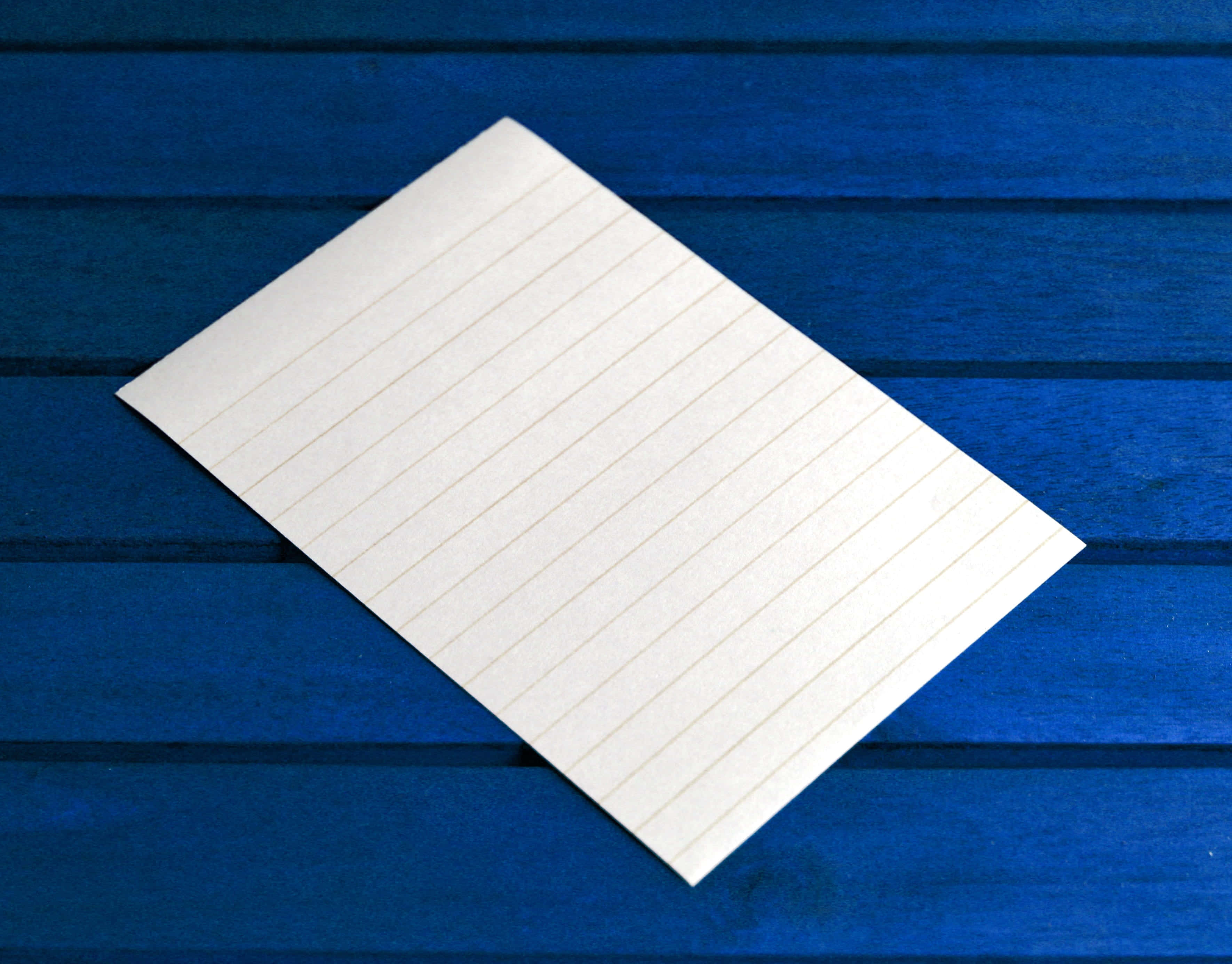 notes 桌布 壁紙 — 空白橫線筆記本頁面對角放置在鮮豔的藍色木質表面上。