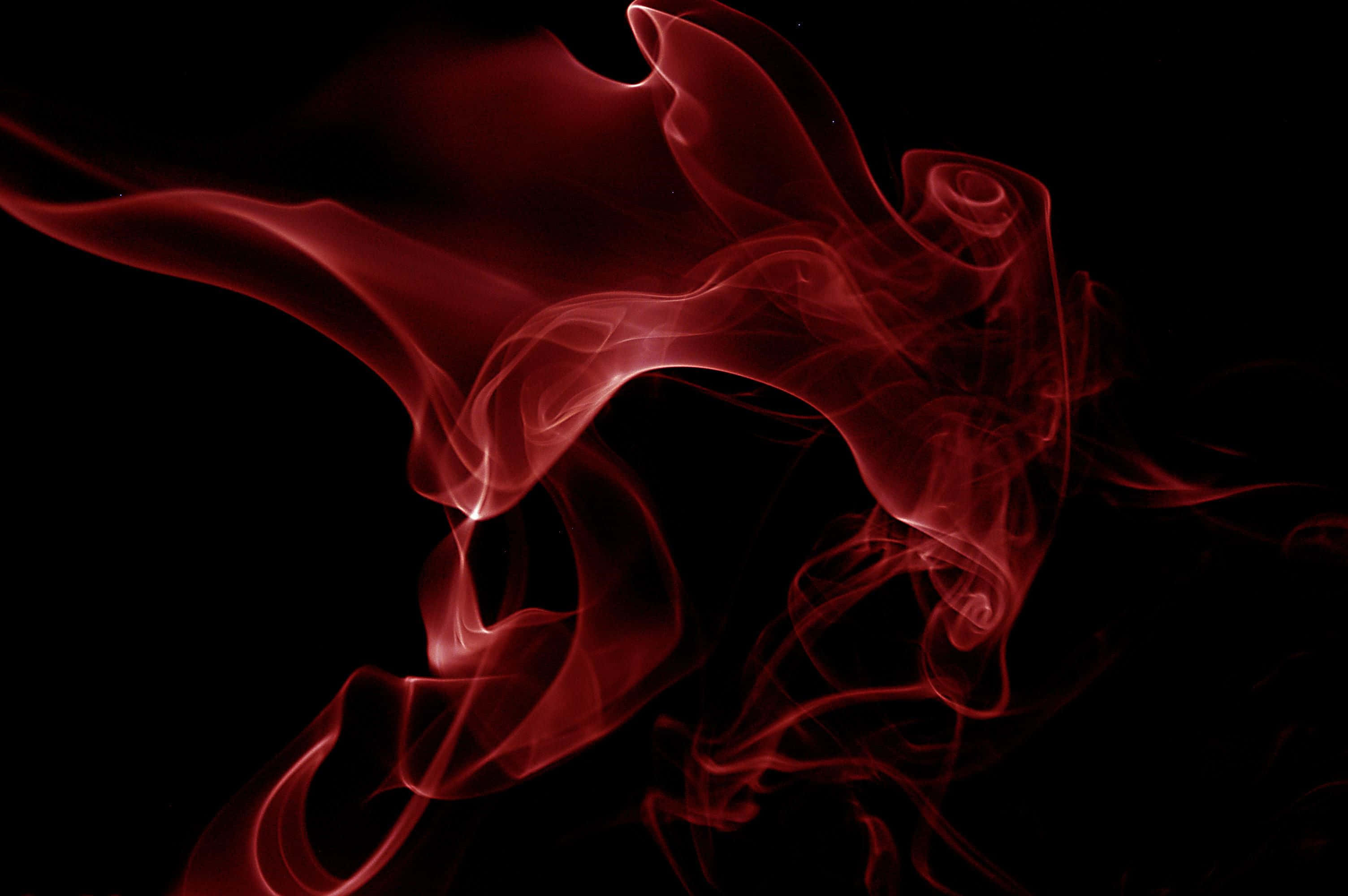 Black Smoke 桌布 壁紙 — 空靈的深紅色煙霧在漆黑虛空中優雅地旋轉，形成一種詭異而美麗的抽象形態。