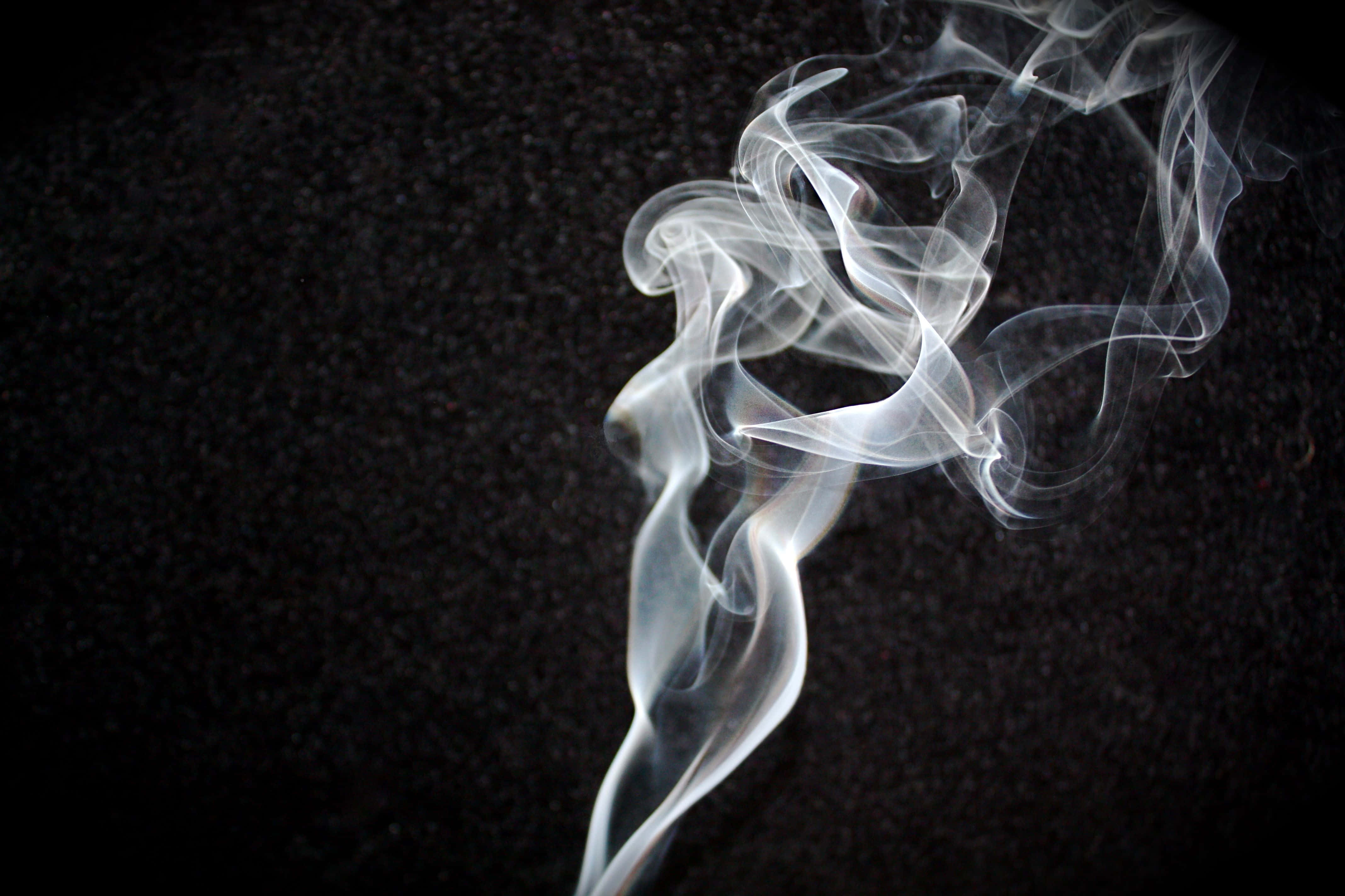 White Smoke 桌布 壁紙 — 空靈的白煙在帶有紋理的黑色背景上優雅地盤旋，形成迷人的抽象舞蹈。