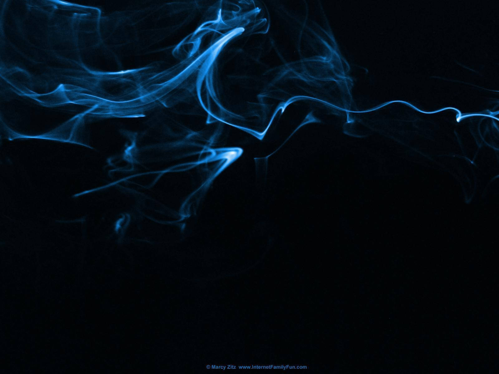 Blue Smoke 桌布 壁紙 — 空靈的藍色煙霧在深邃的黑色虛空中優雅地旋轉，營造出神秘而平靜的視覺效果。