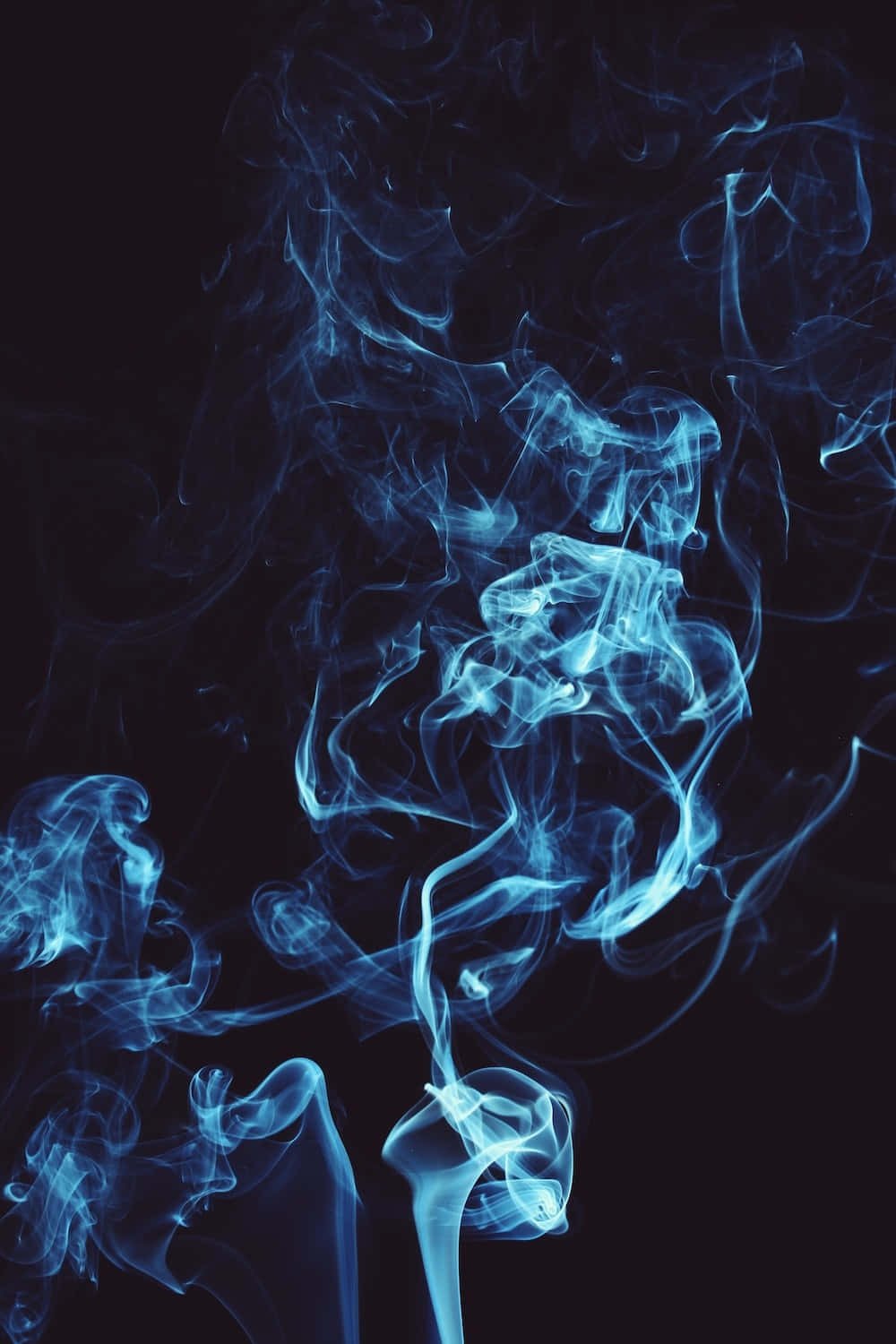Smoky 桌布 壁紙 — 空靈的藍色煙霧在深黑色背景上優雅地旋轉，營造出迷人的抽象動感。