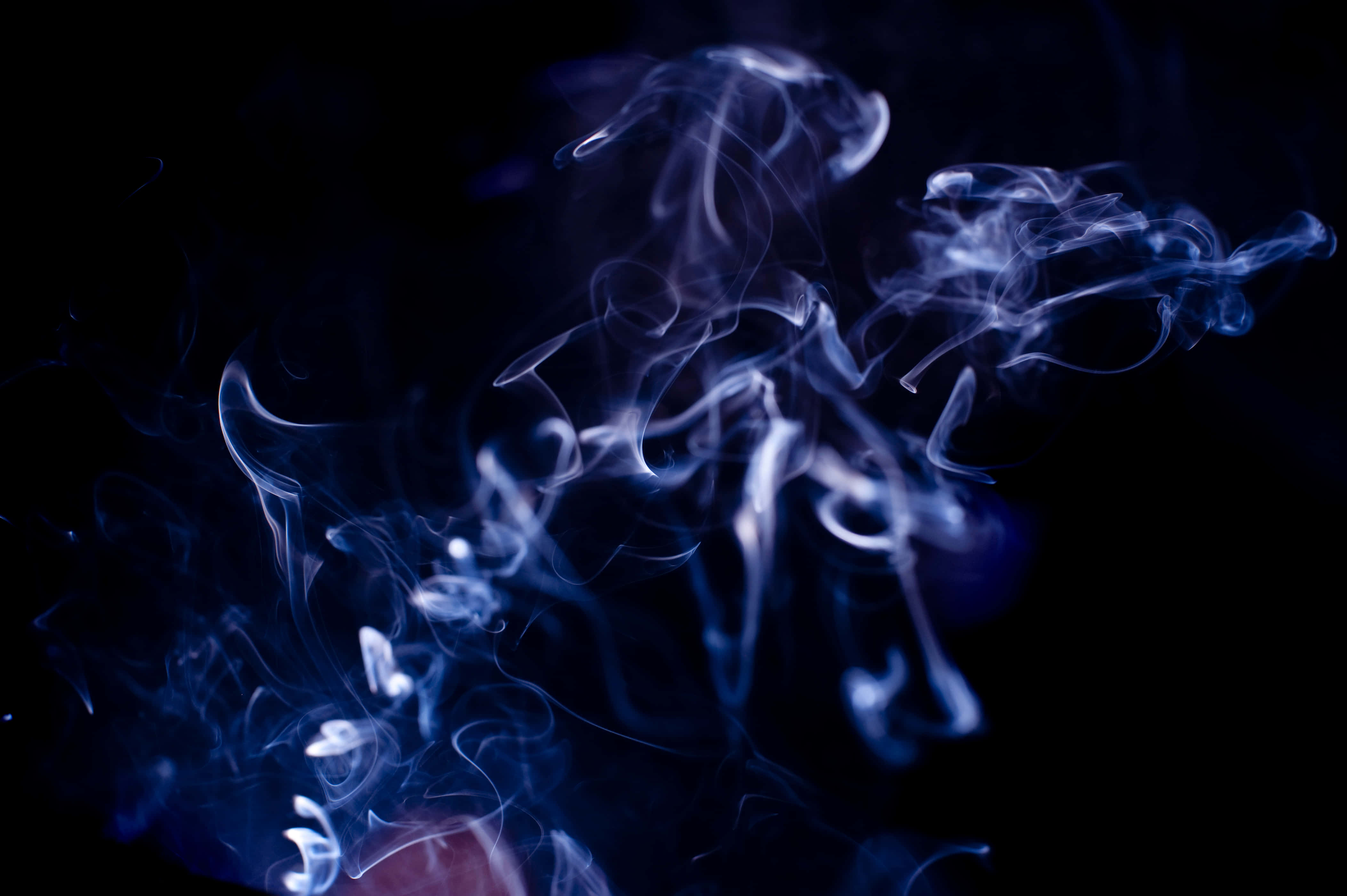 Ethereal 桌布 壁紙 — 空靈的藍色煙霧在深黑色背景上優雅地旋轉，營造出神秘而平靜的視覺效果。