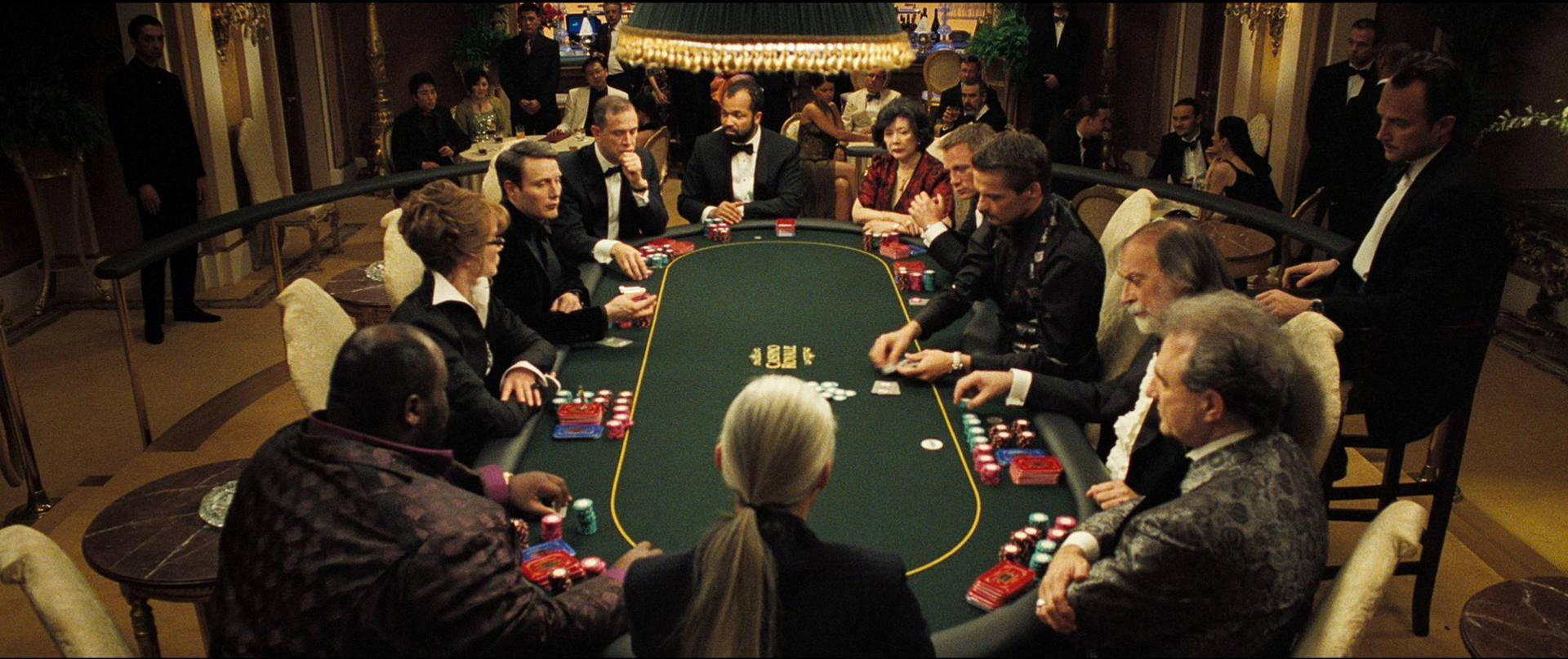 Poker 桌布 壁紙 — 穿著正式服裝的優雅賭場顧客在溫暖吊燈燈光下激烈地玩撲克牌。