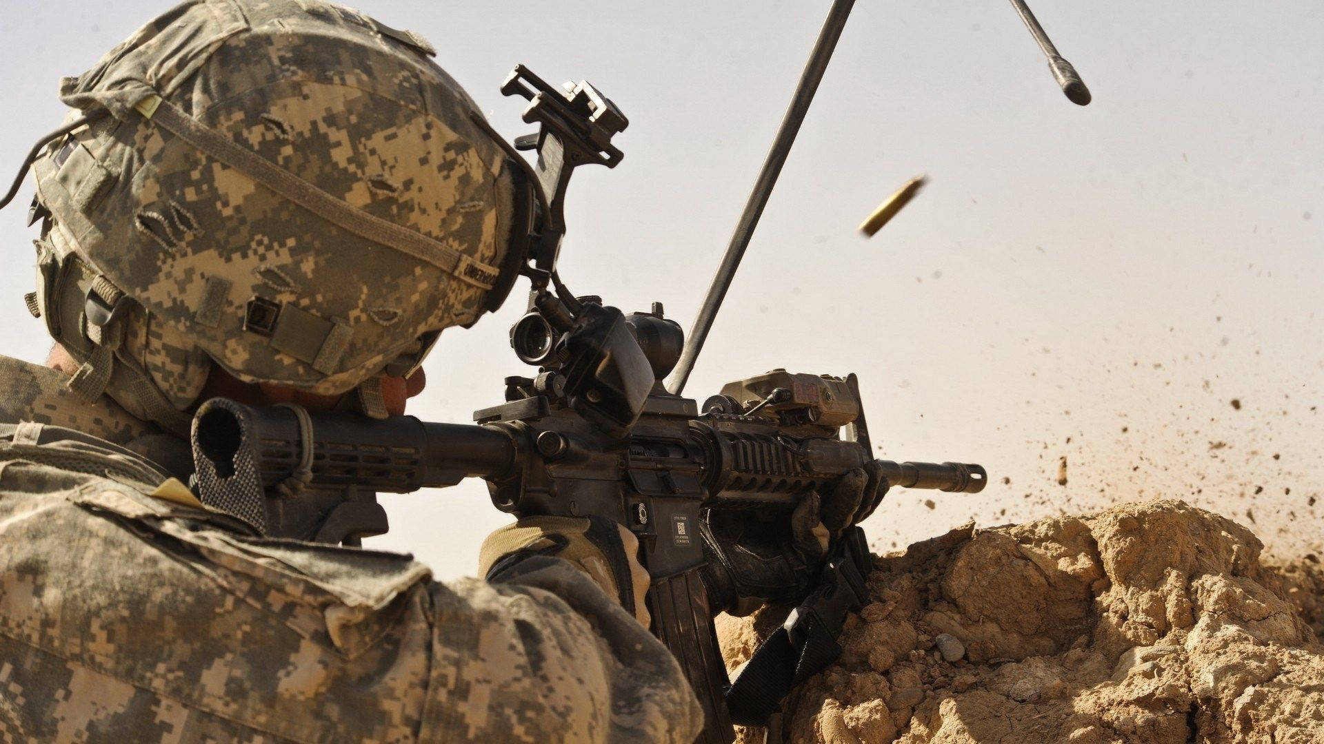 US 桌布 壁紙 — 穿著沙漠迷彩的士兵在乾旱地形中開槍，子彈和灰塵爆炸。