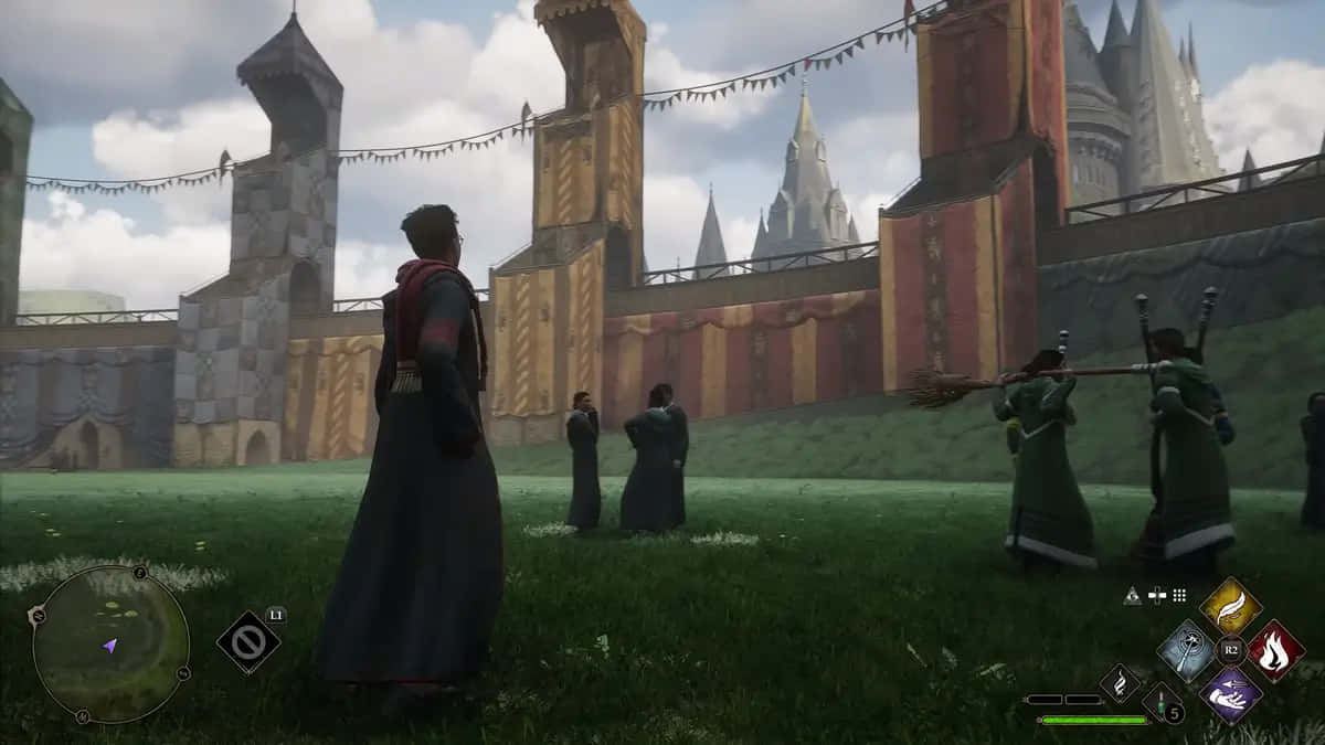 The Hogwarts Quidditch Pitch 桌布 壁紙 — 穿著深色長袍的學生站在城堡前的草地上，城堡上有旗幟和塔樓，天空多雲。