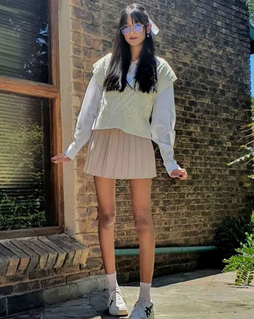穿著白色毛衣和百褶裙的女孩 壁紙