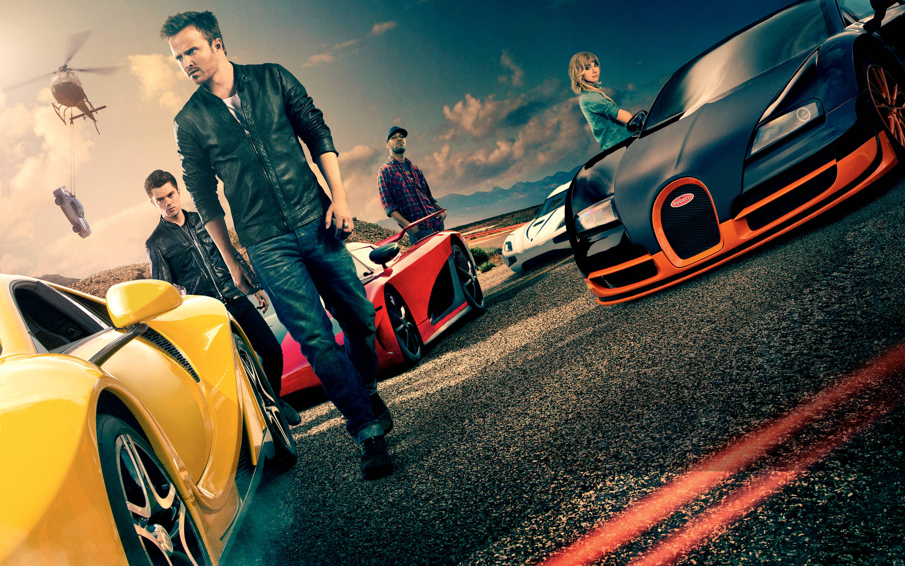 Need For Speed 桌布 壁紙 — 穿著皮夾克的男人站在沙漠公路上，旁邊是色彩鮮豔的超級跑車，一架直升機在頭頂盤旋。