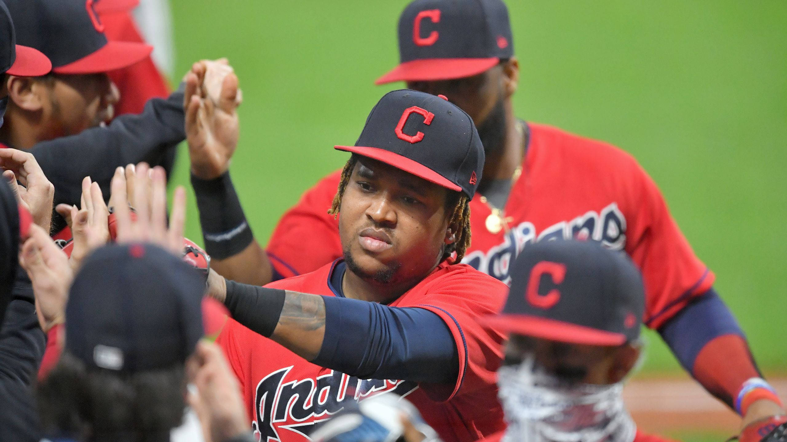 Jose Ramirez 桌布 壁紙 — 穿著紅色球衣的克里夫蘭印地安人棒球選手在綠色球場上與隊友擊掌慶祝。