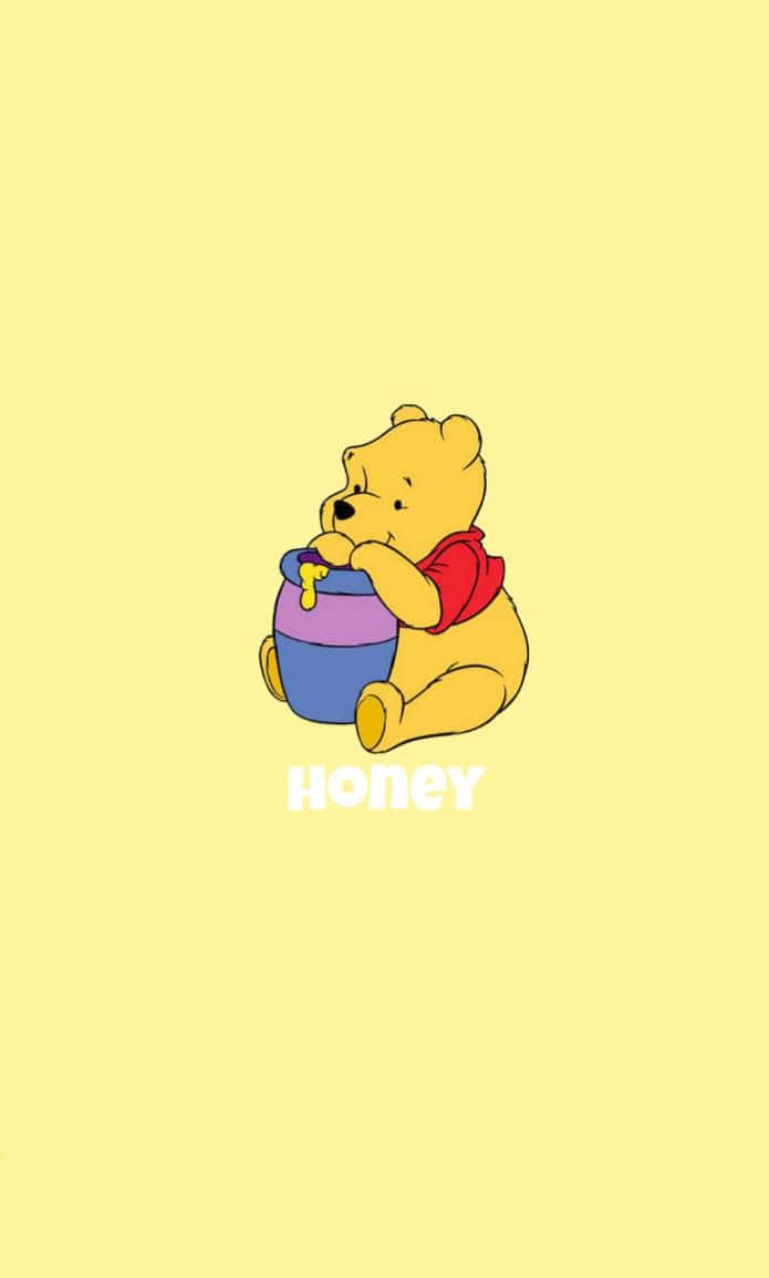 Winnie The Pooh Aesthetic 桌布 壁紙 — 穿著紅色襯衫的小熊維尼開心坐著，擁抱一個色彩繽紛的蜂蜜罐，背景是柔和的黃色。