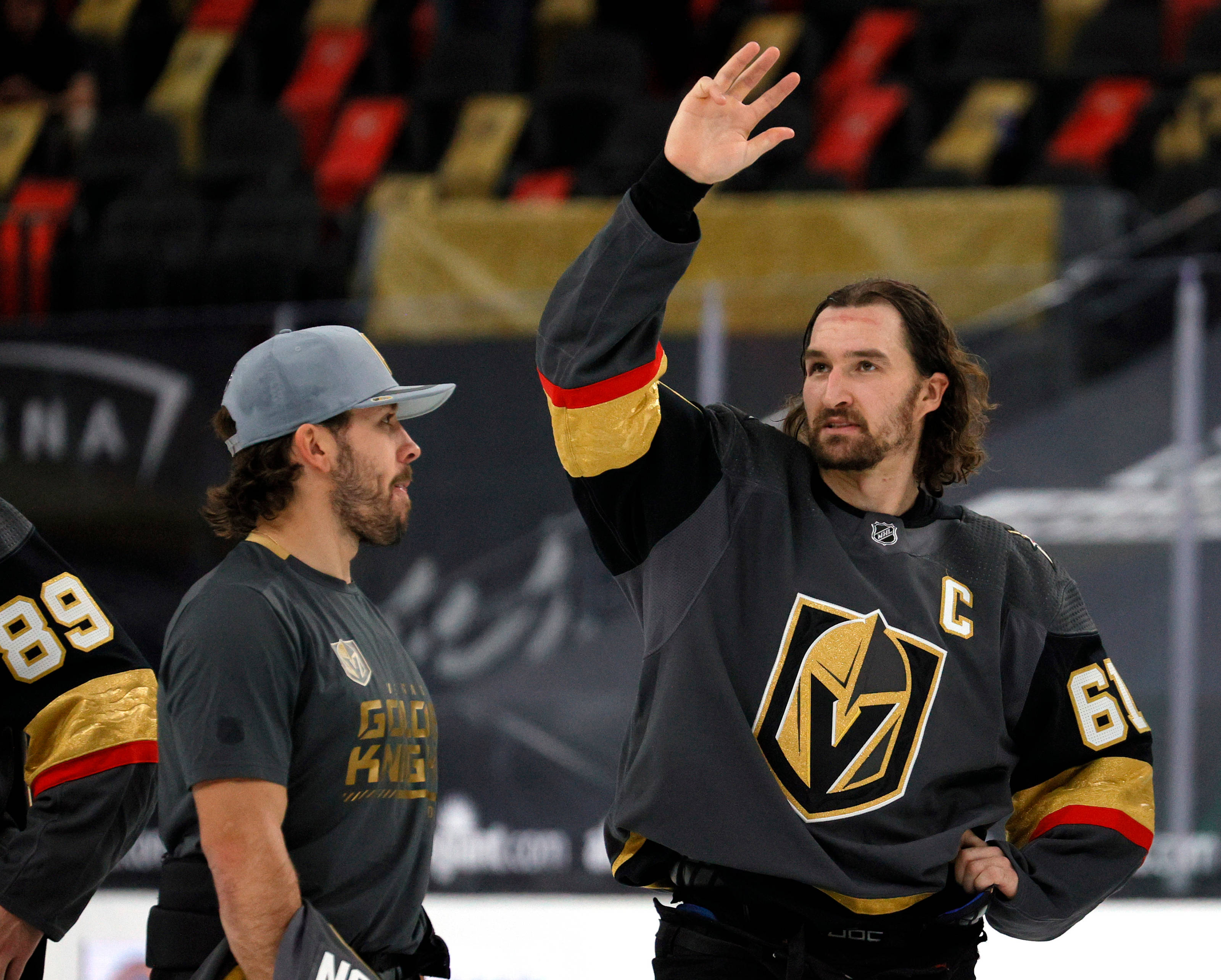 hockey 桌布 壁紙 — 穿著維加斯金騎士球衣的冰球運動員在冰場上向球迷揮手，隊友在他旁邊。